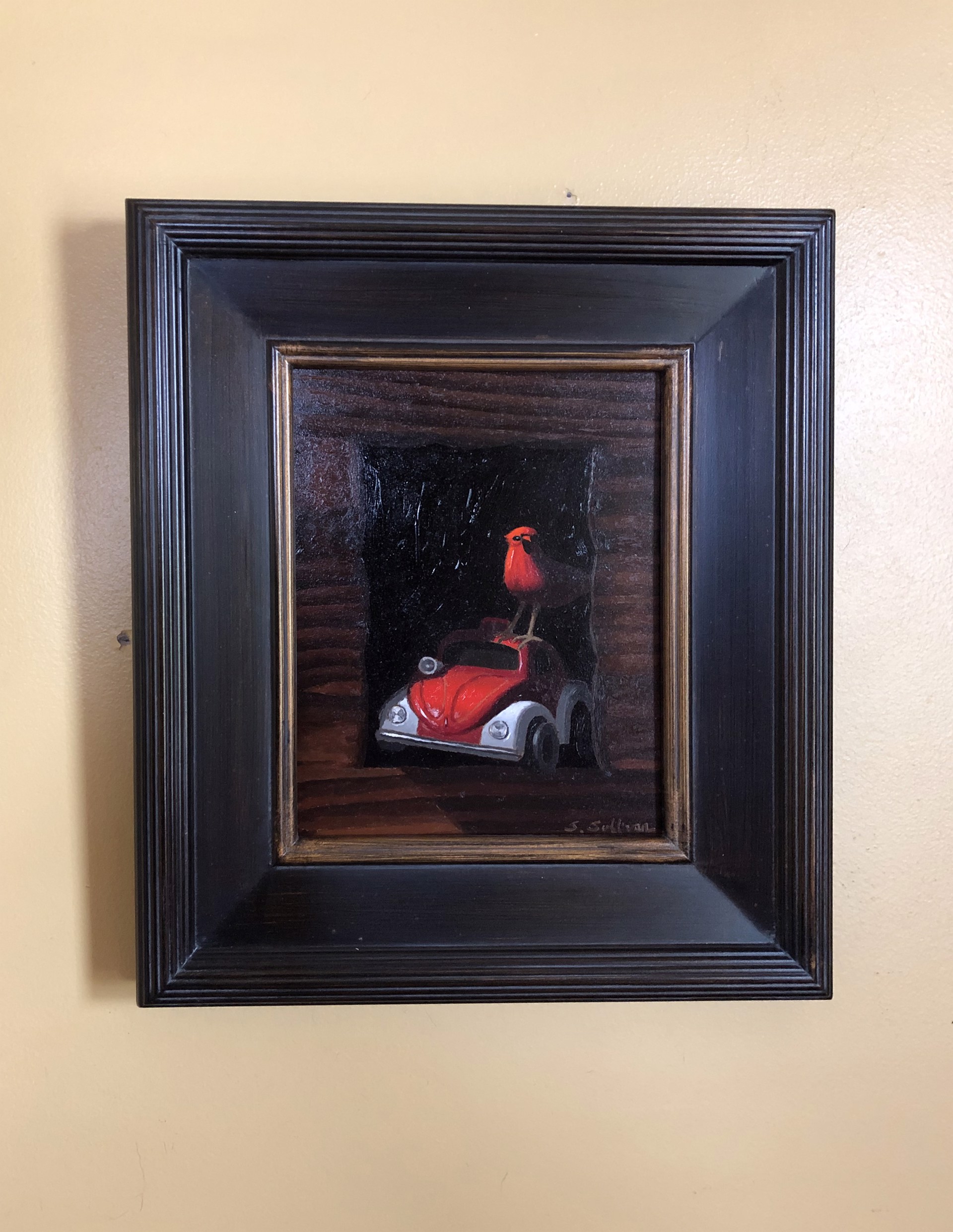 A painting of a red bird sitting on top of a car.