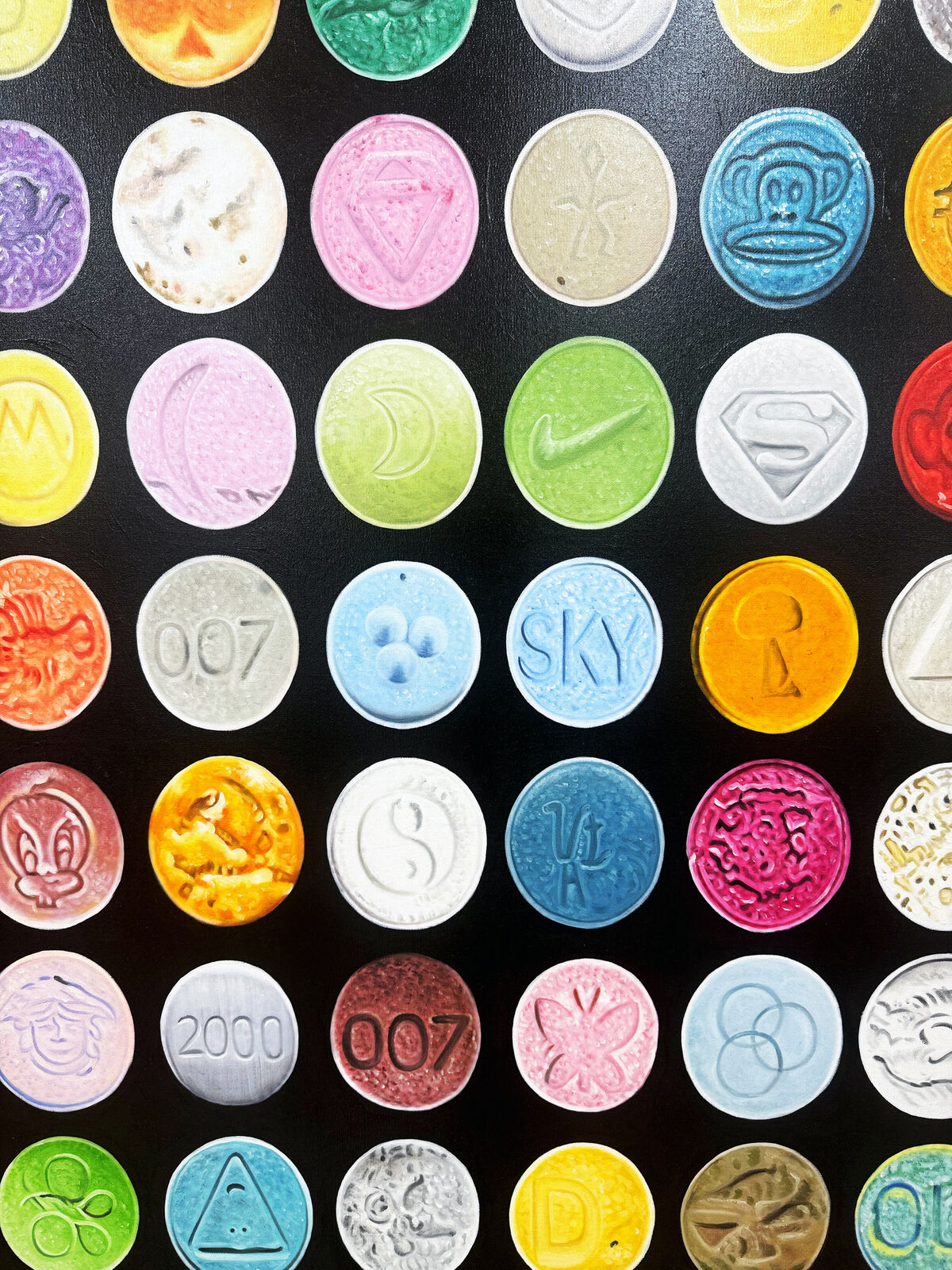 A grid of colorful, embossed circular objects arranged on a black background.