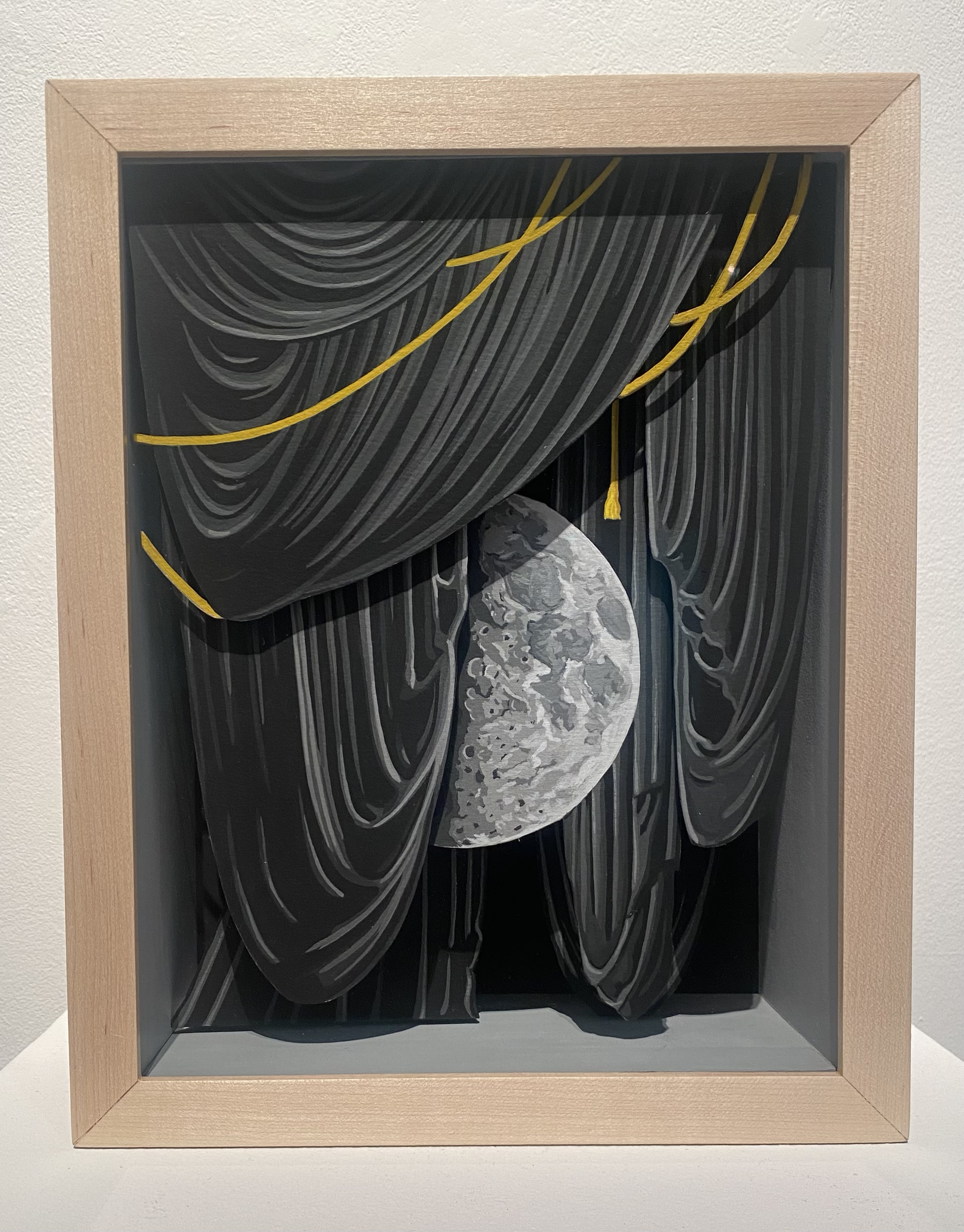 A shadow box with a drawing of a moon in it.
