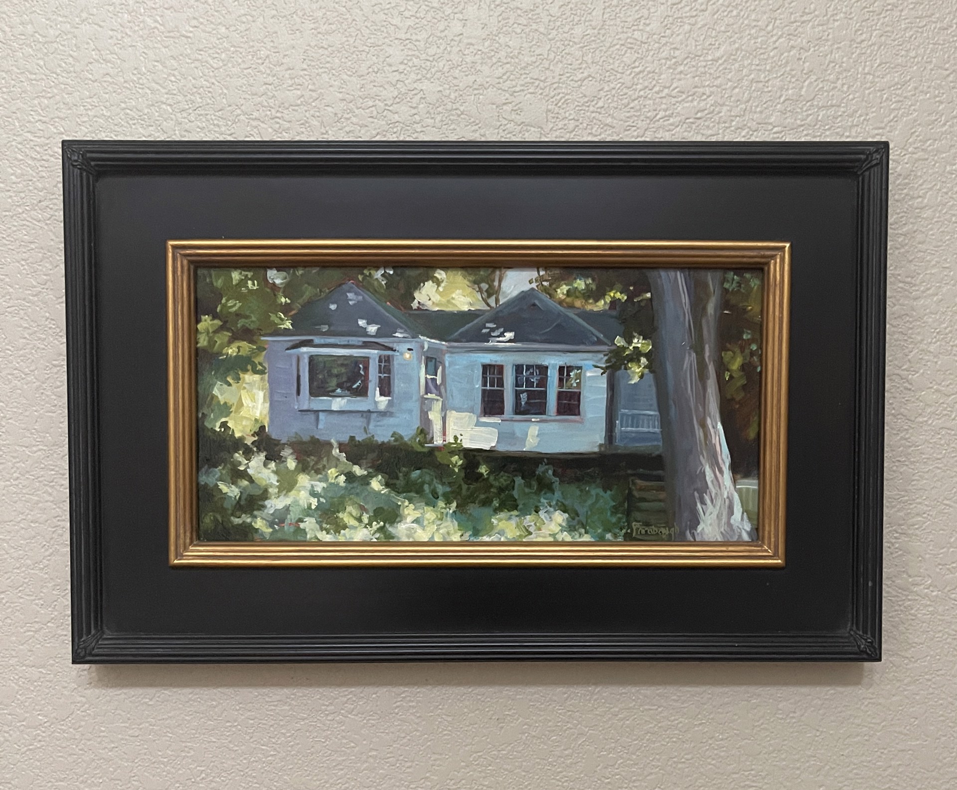 A painting of a blue house in the woods.