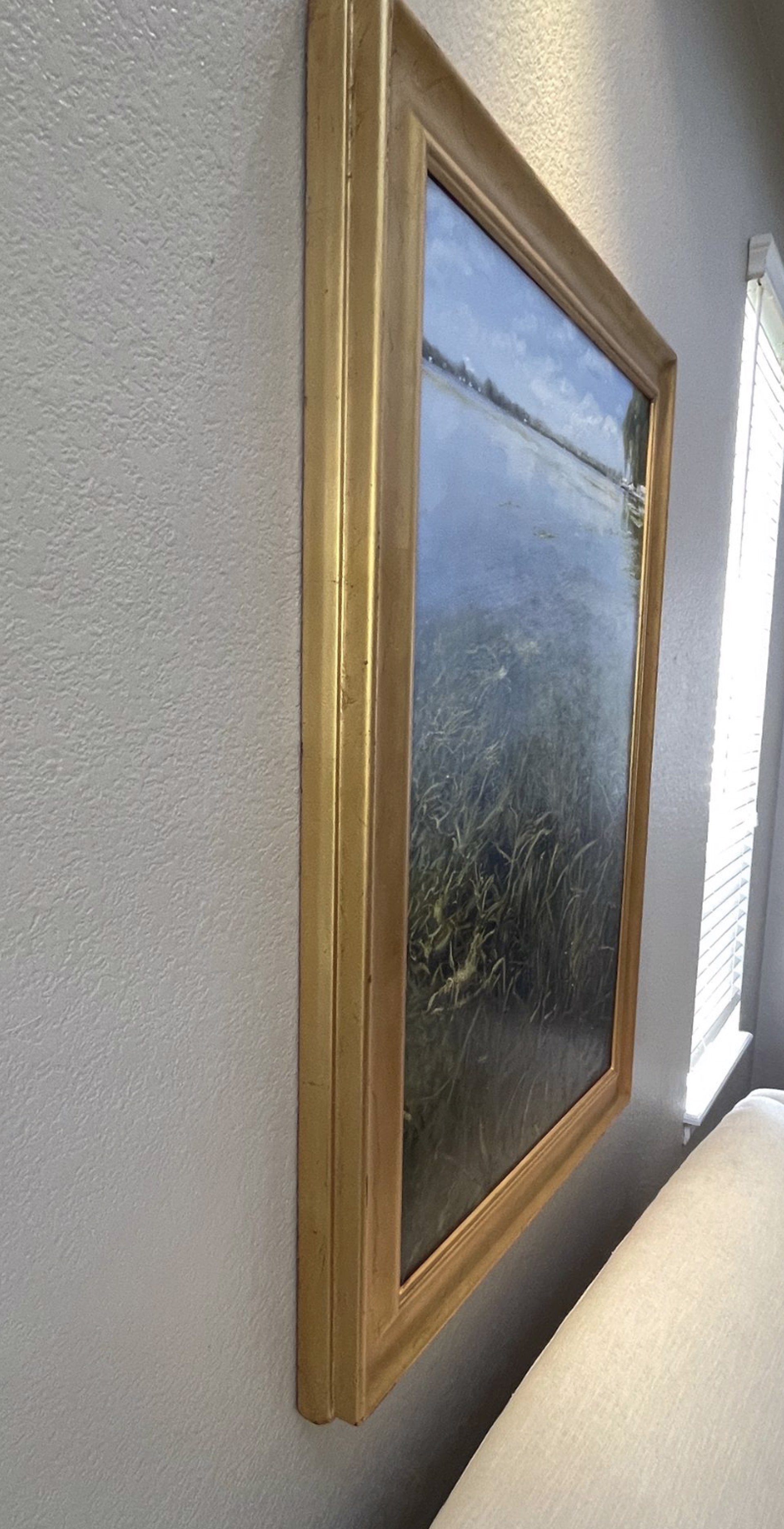 A painting of a body of water surrounded by tall grass.