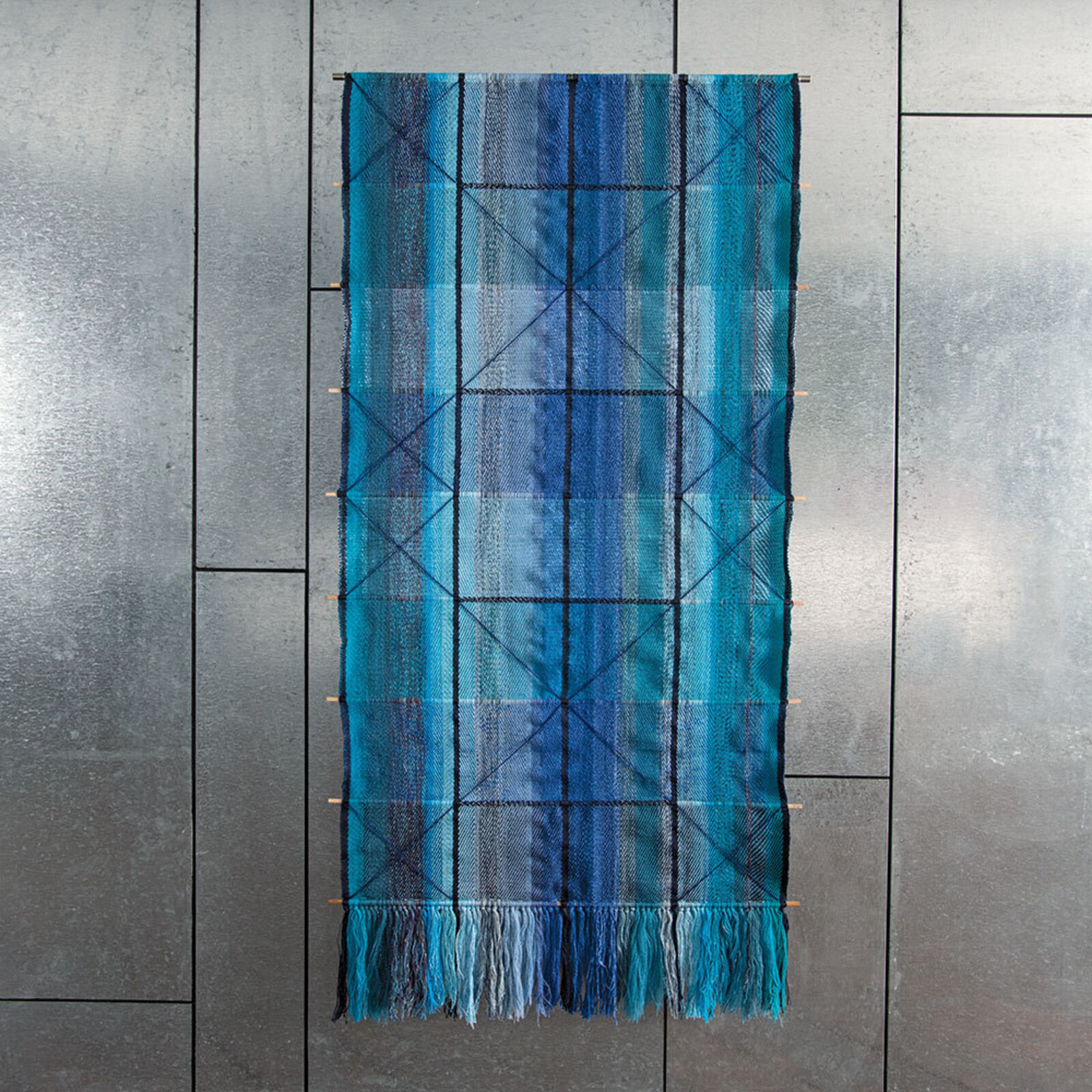 A blue and black scarf hanging on a wall.