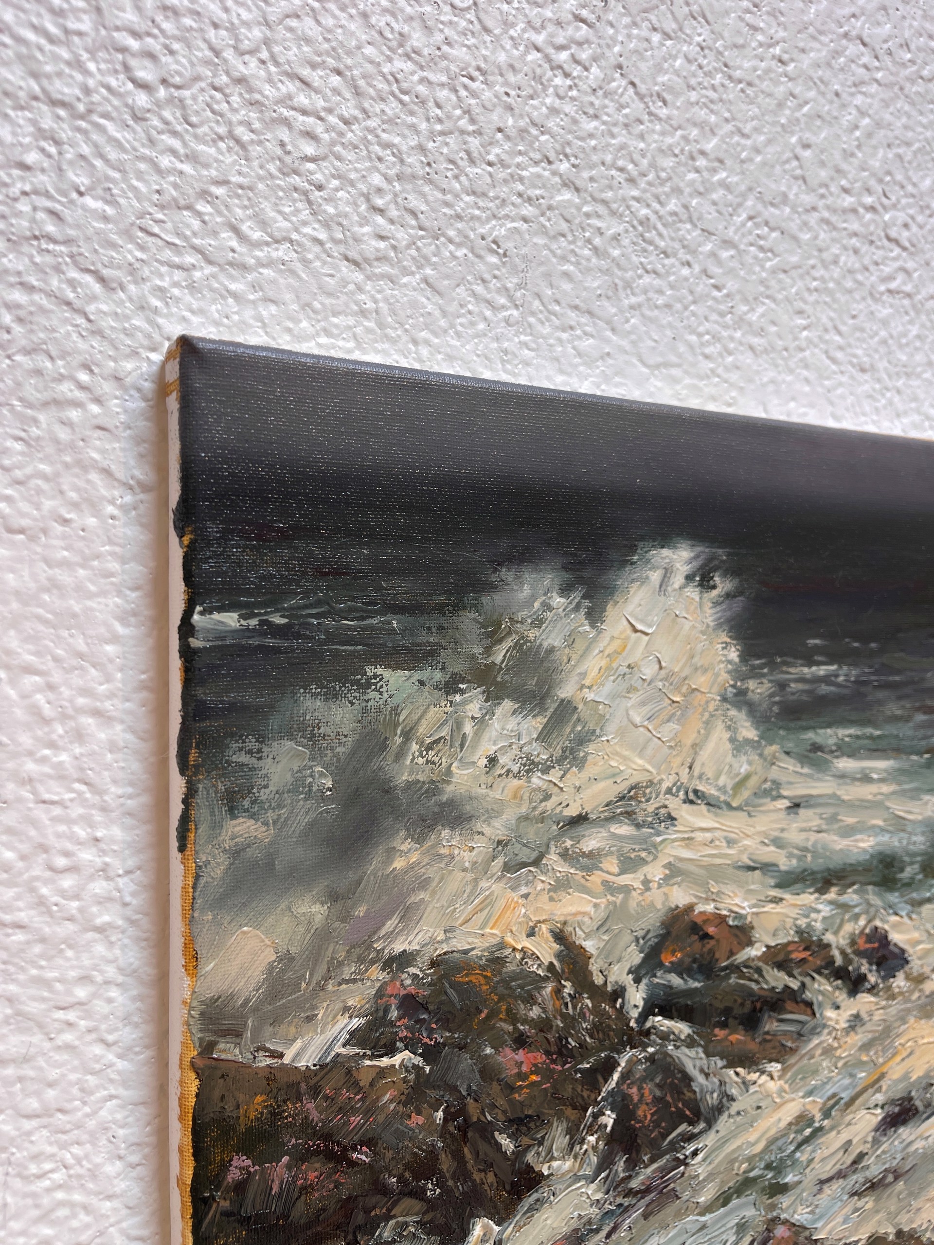 A painting of waves crashing on rocks in the ocean.