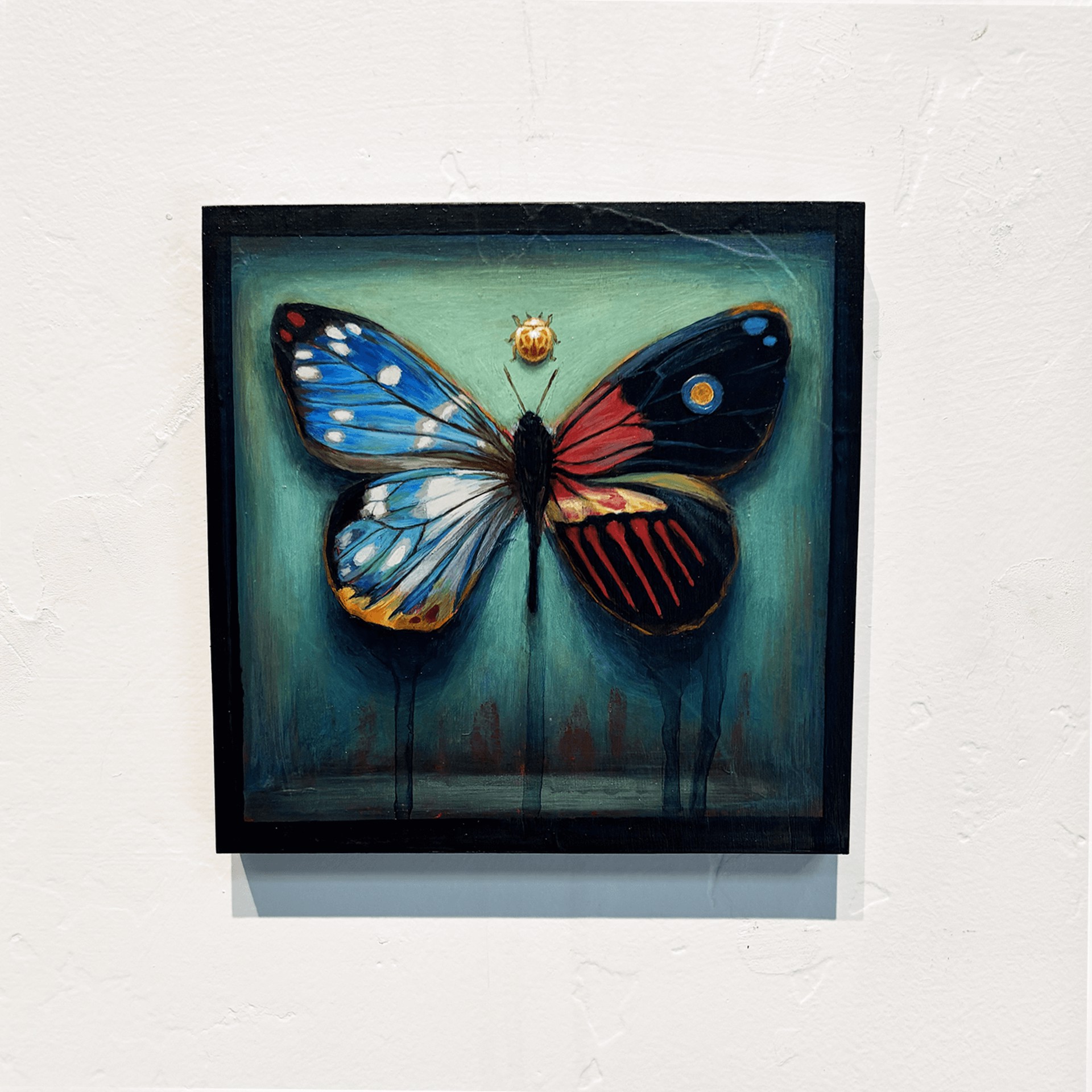 A painting of a butterfly and a ladybug on a green background.