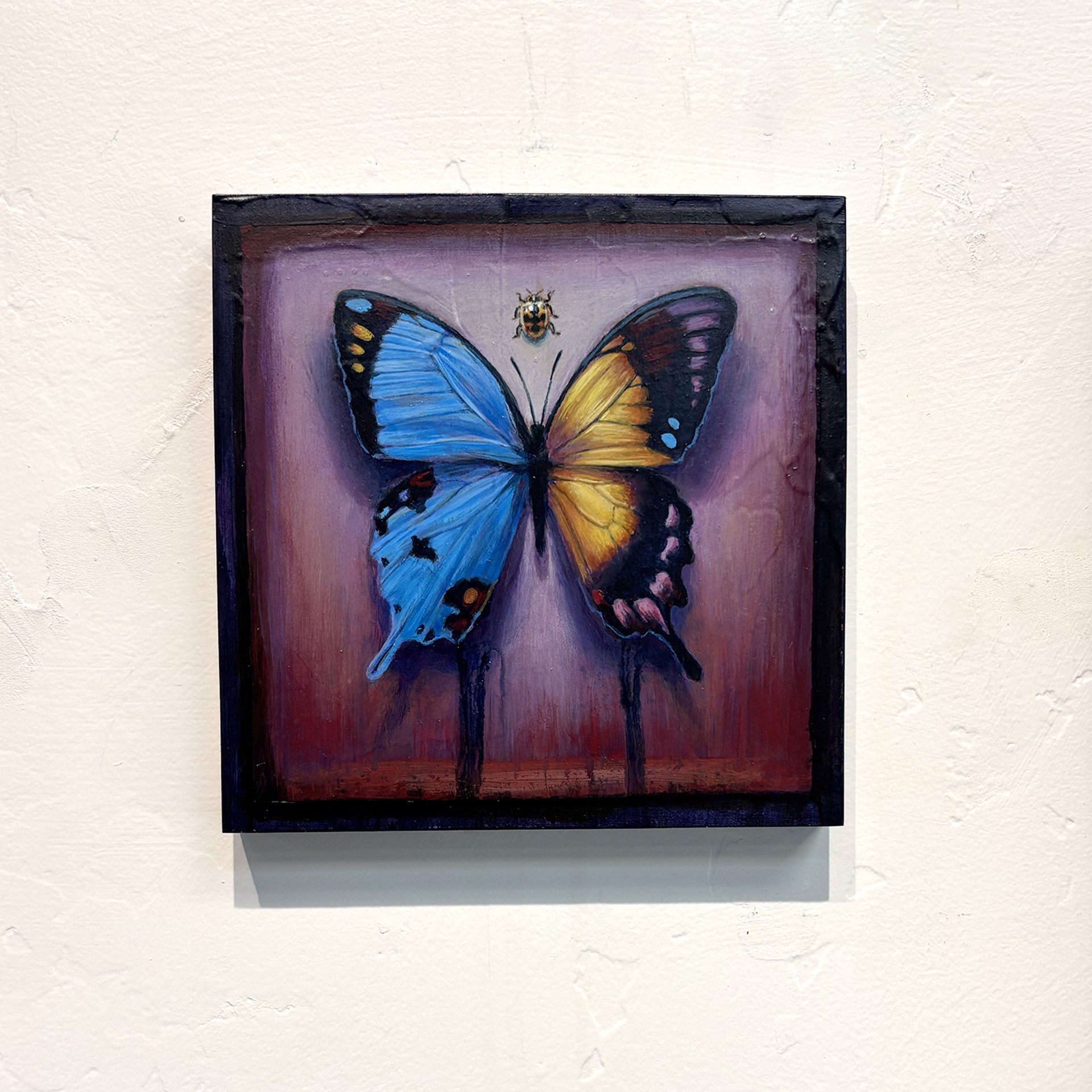 A painting of a butterfly and a ladybug on a purple background.
