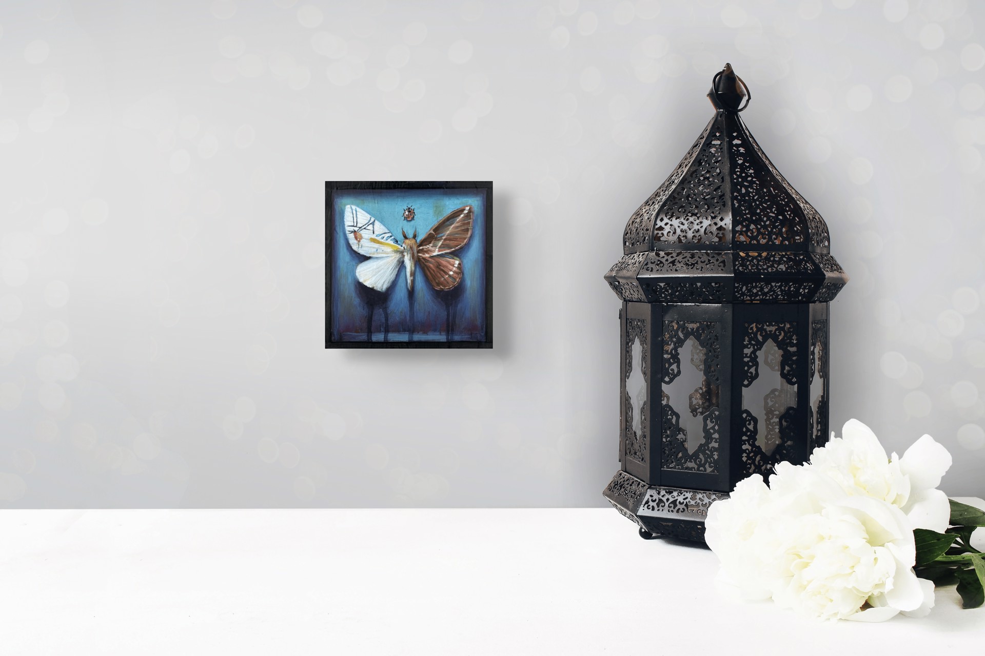 A painting of a moth and a ladybug on a blue background.