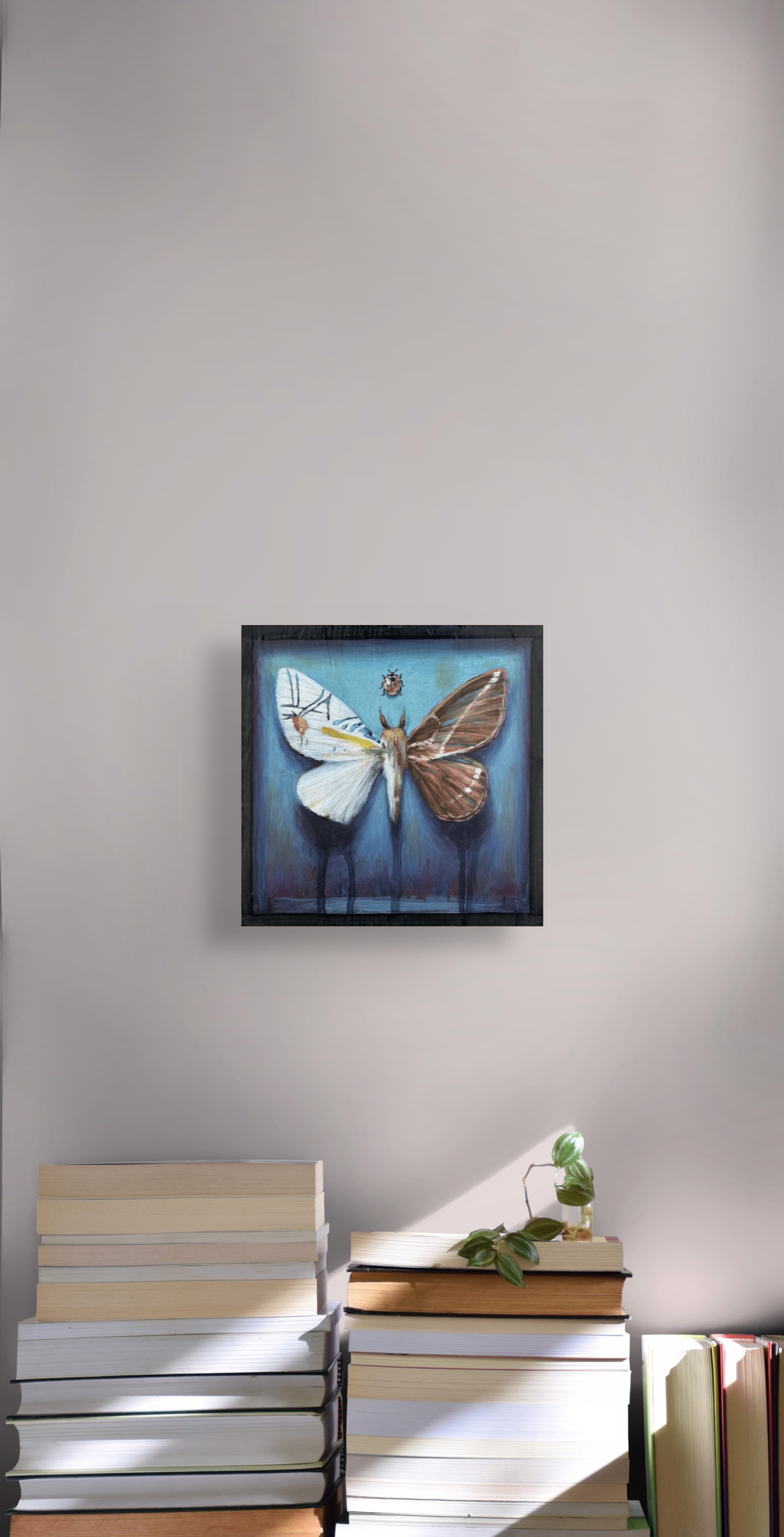 A painting of a moth and a ladybug on a blue background.