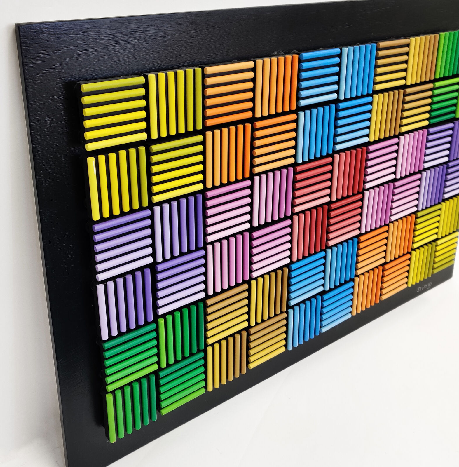 A painting of a colorful pattern of colored pencils on a black background.