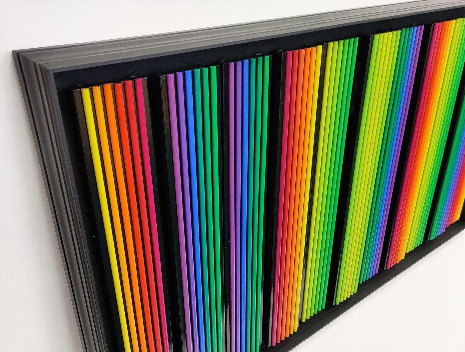 A black frame with a bunch of colored pencils on it.