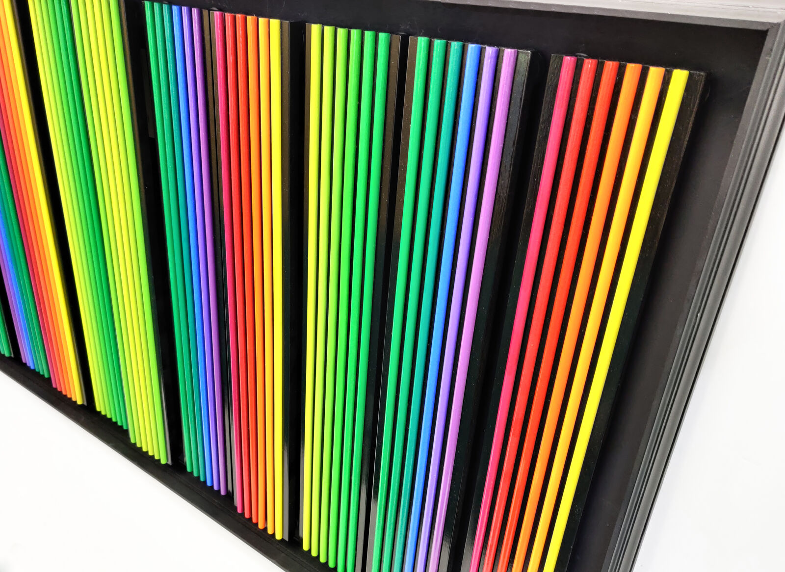 A black frame with a bunch of colored pencils on it.
