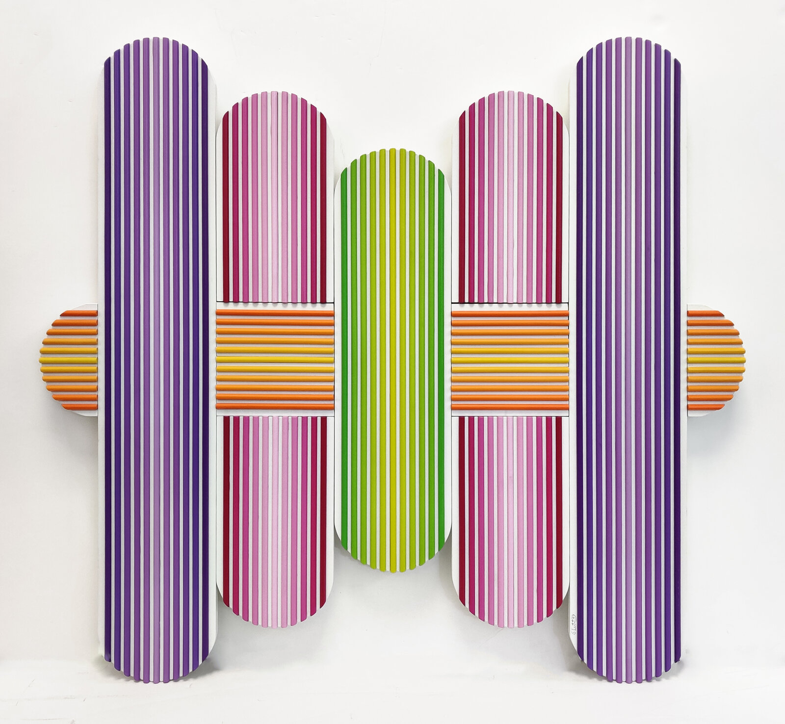 A group of colorful striped skateboards on a white wall.