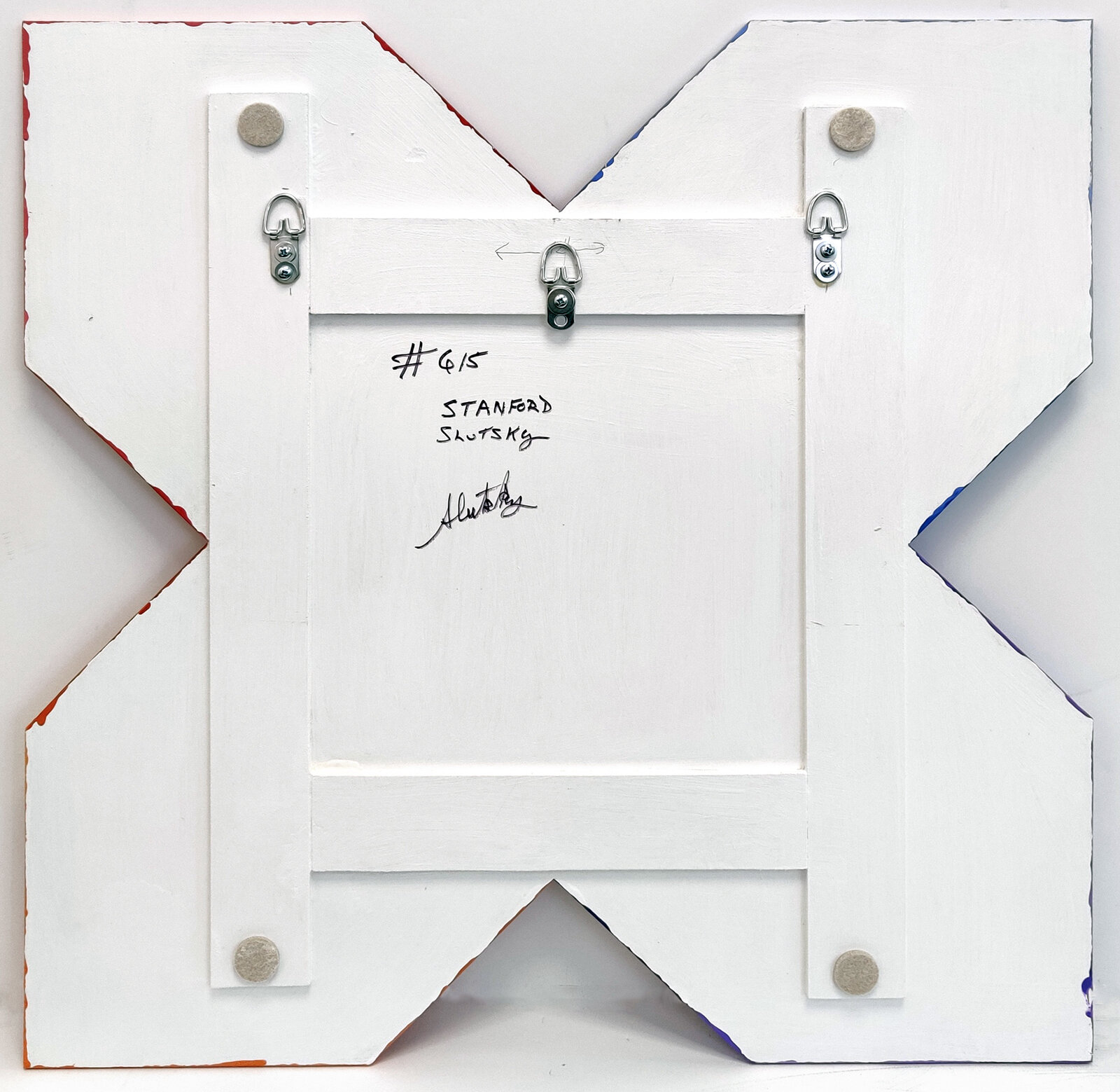 A colorful geometric piece of art on a white wall.