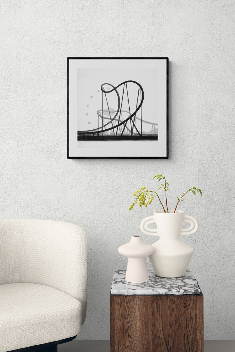 A monochrome sketch of a roller coaster track with abstract support structures and floating circles.
