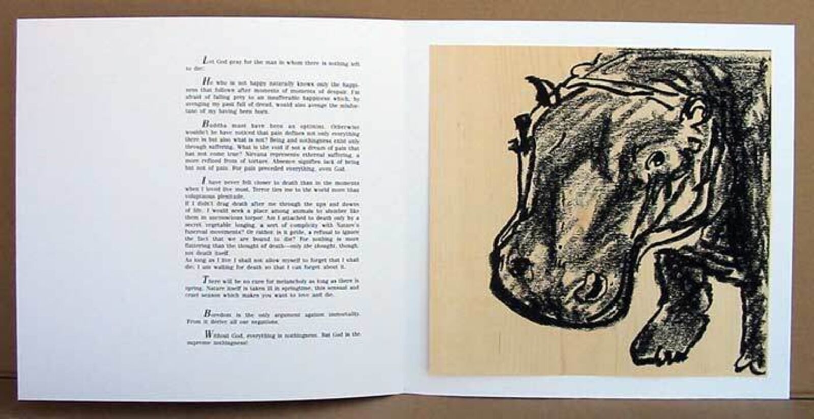 A black and white drawing of a hippo on a piece of wood.