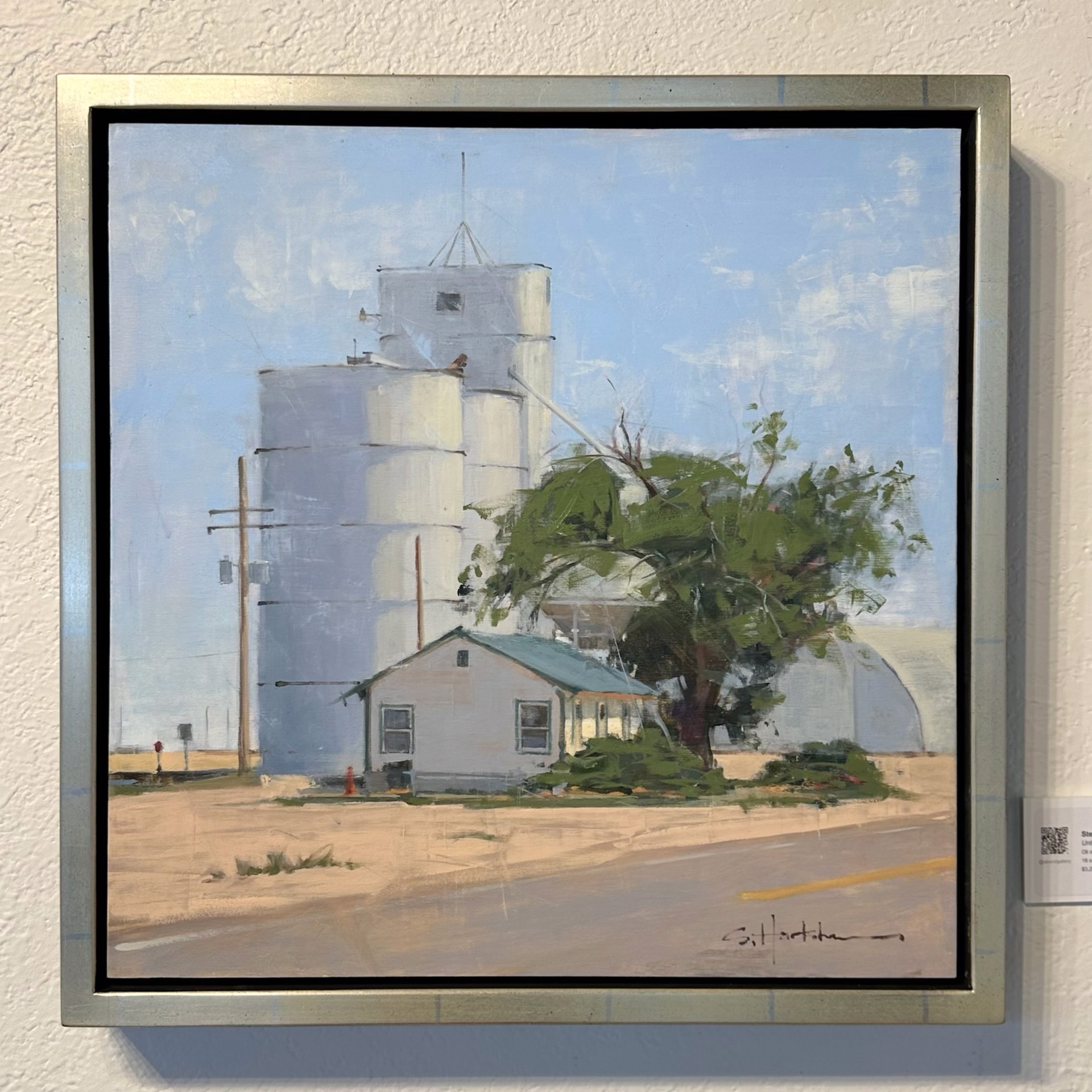 A painting of two white silos on the side of a road.