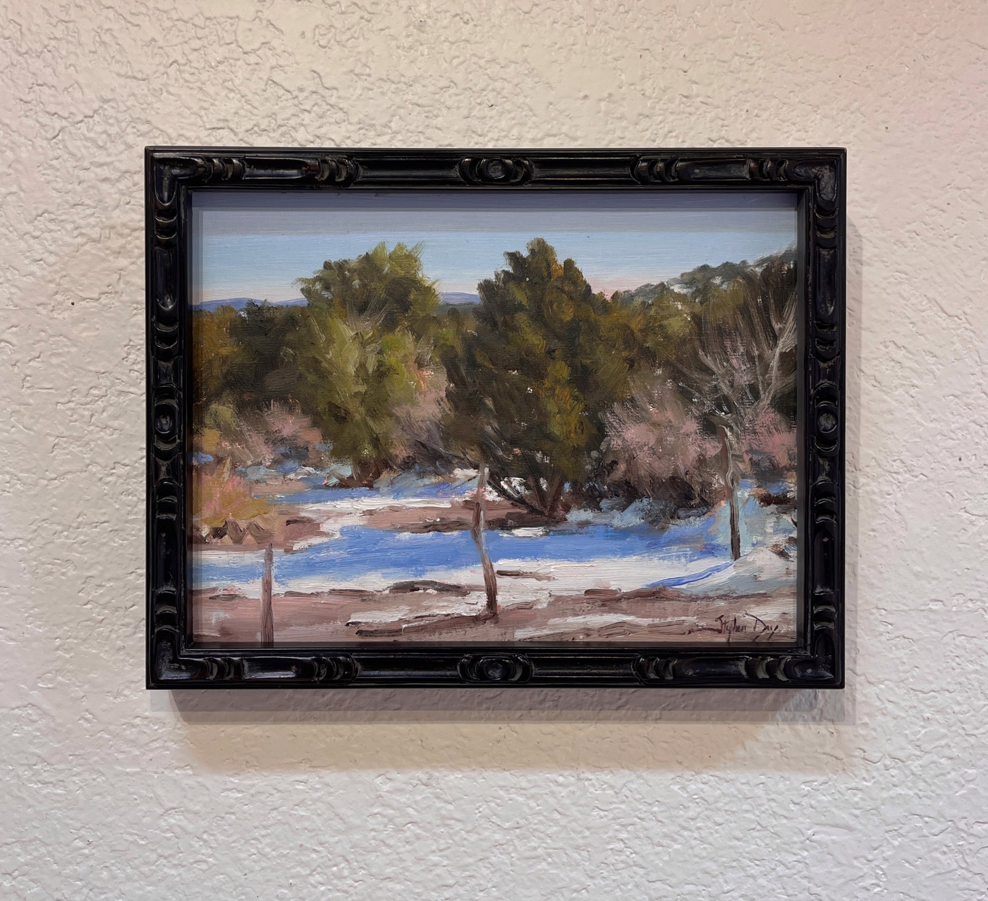 A painting of a snowy landscape with trees in the background.