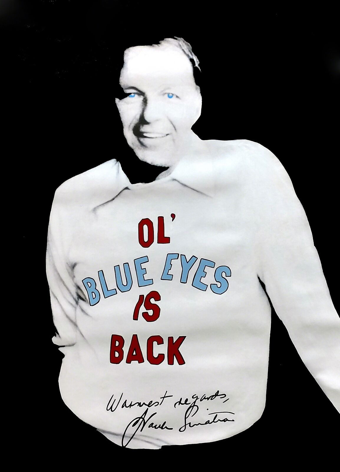 A black and white photo of a man wearing a sweatshirt that says "Ol' Blue Eyes is Back."