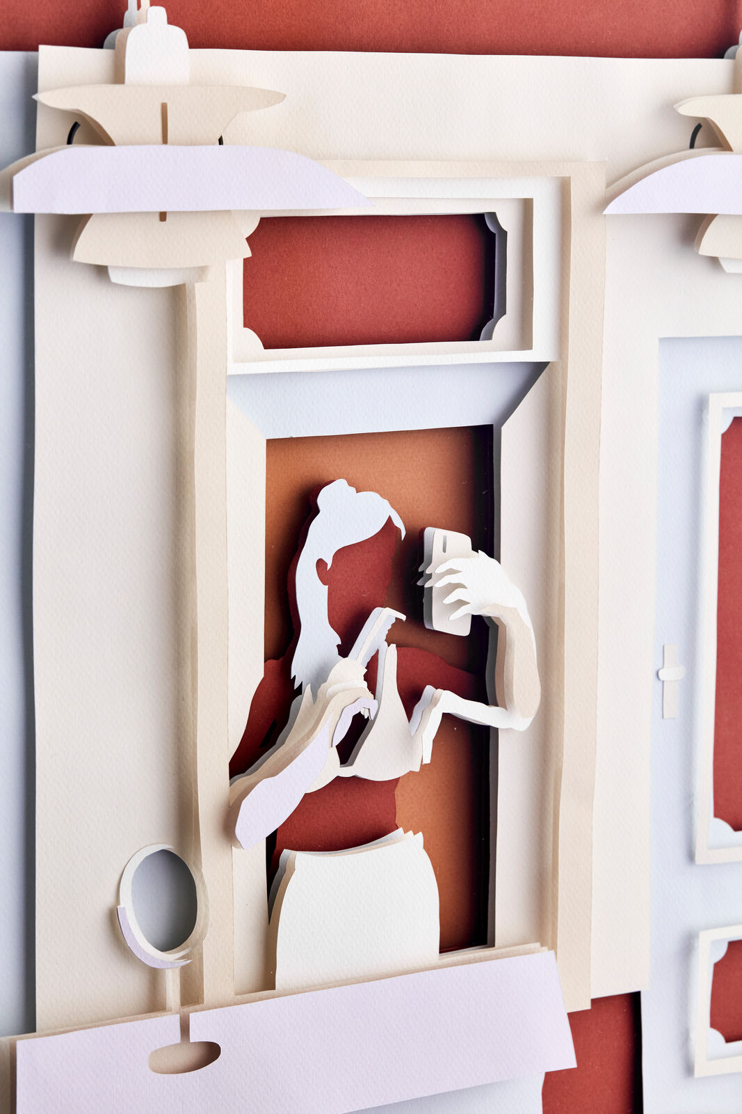 A paper cut of a woman in a bathroom.