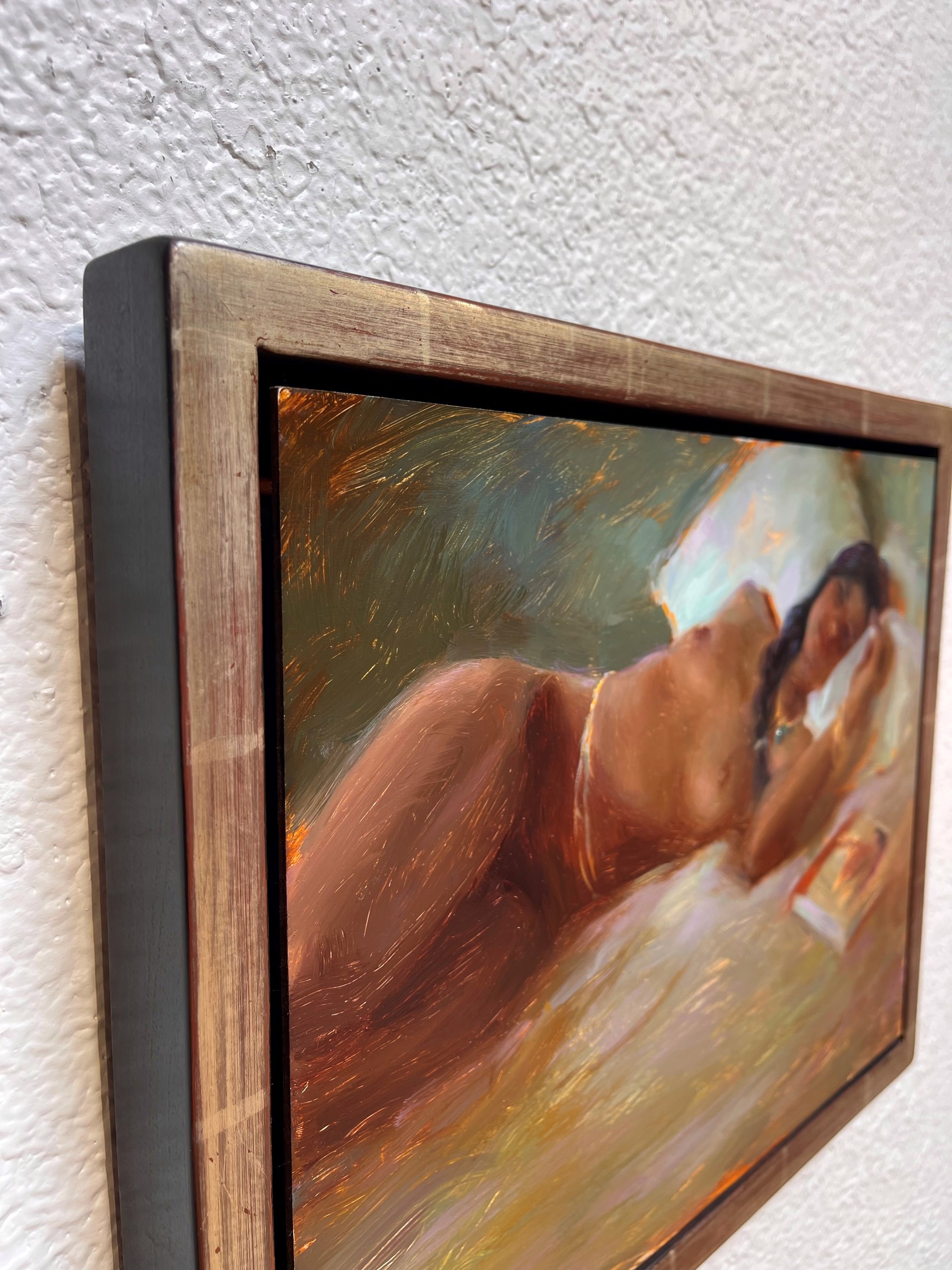 A painting of a woman laying on a bed reading a book.