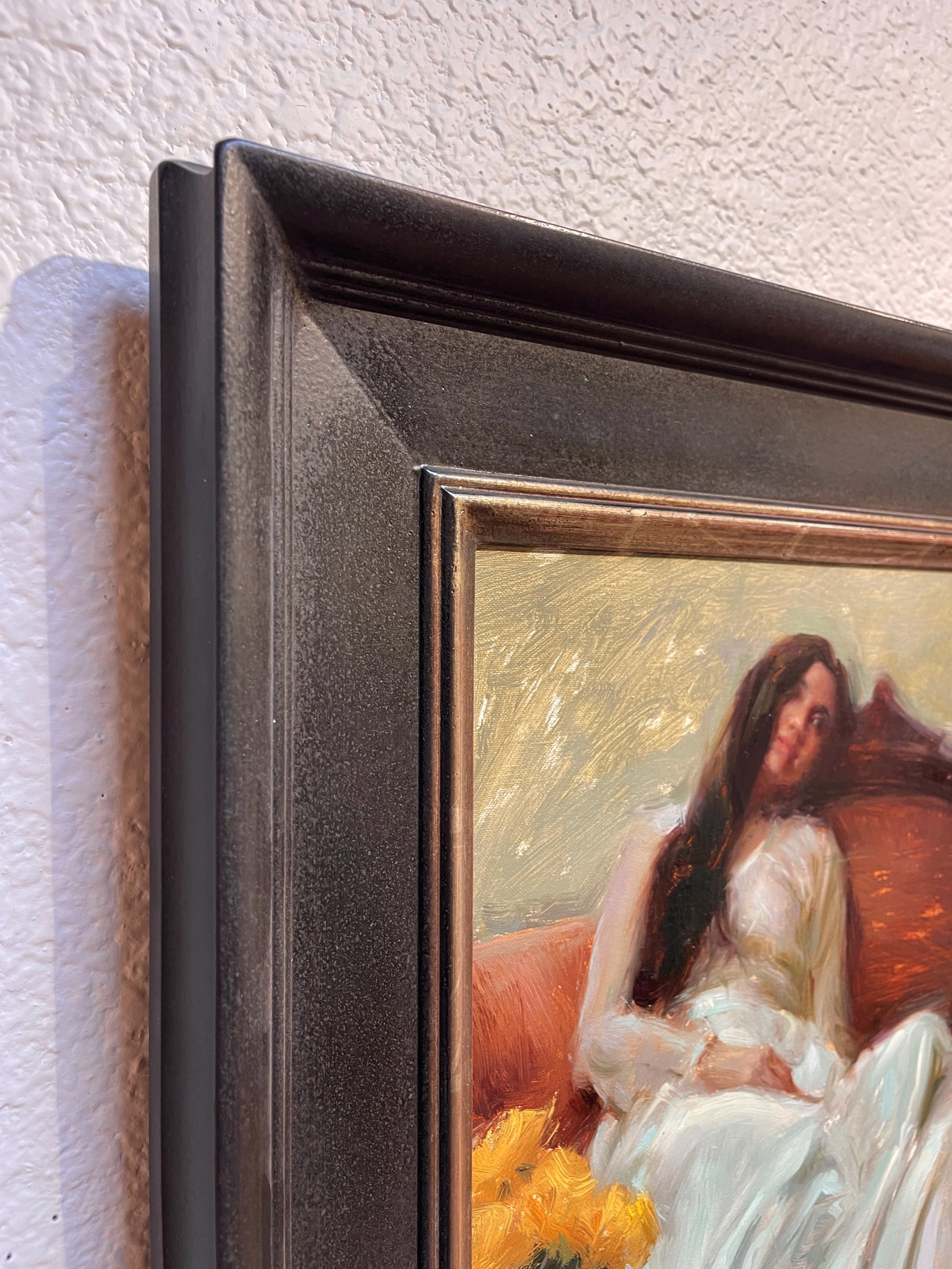 A painting of a woman sitting on a couch with a vase of flowers.