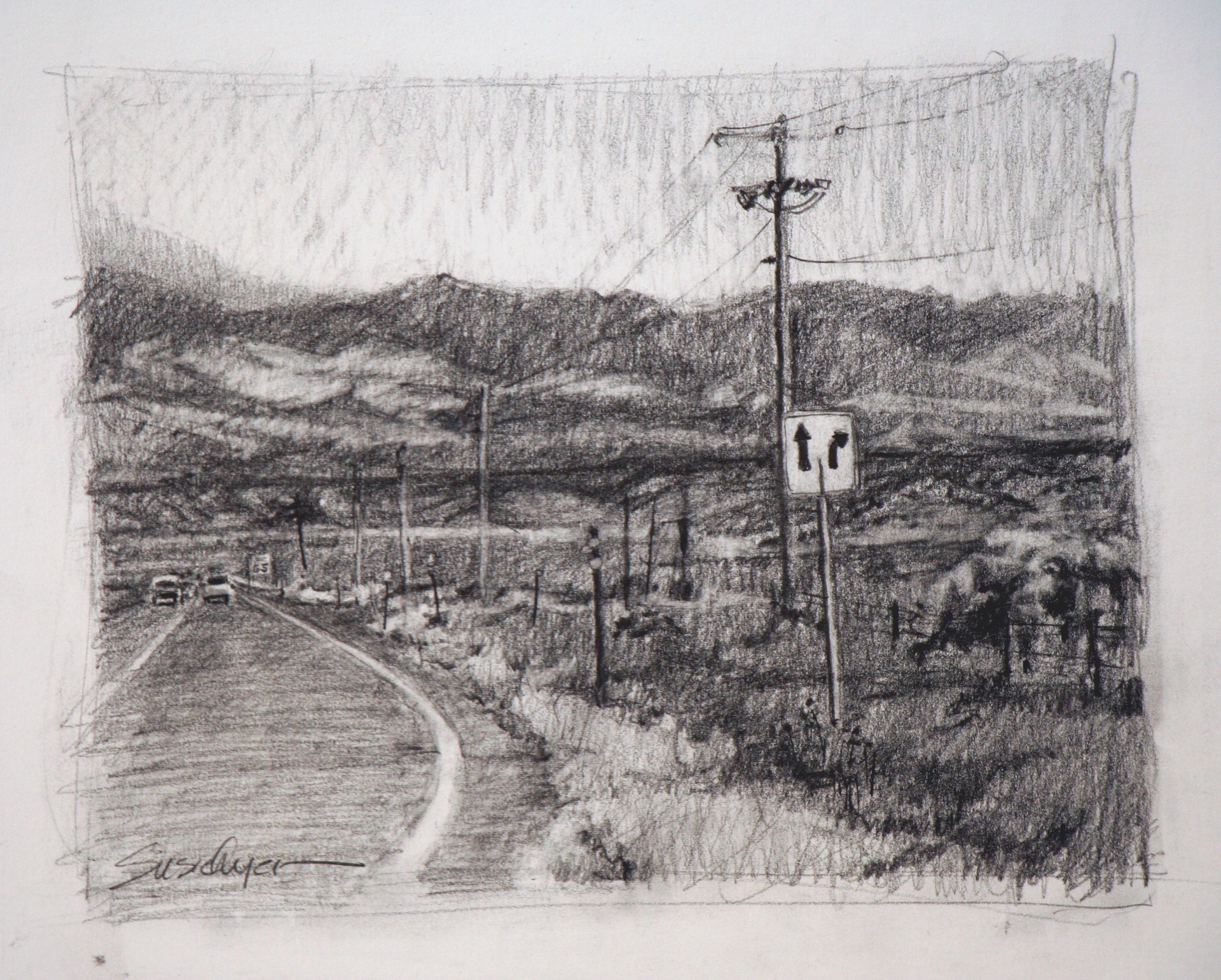 A monochromatic road scene with hills and a utility pole.