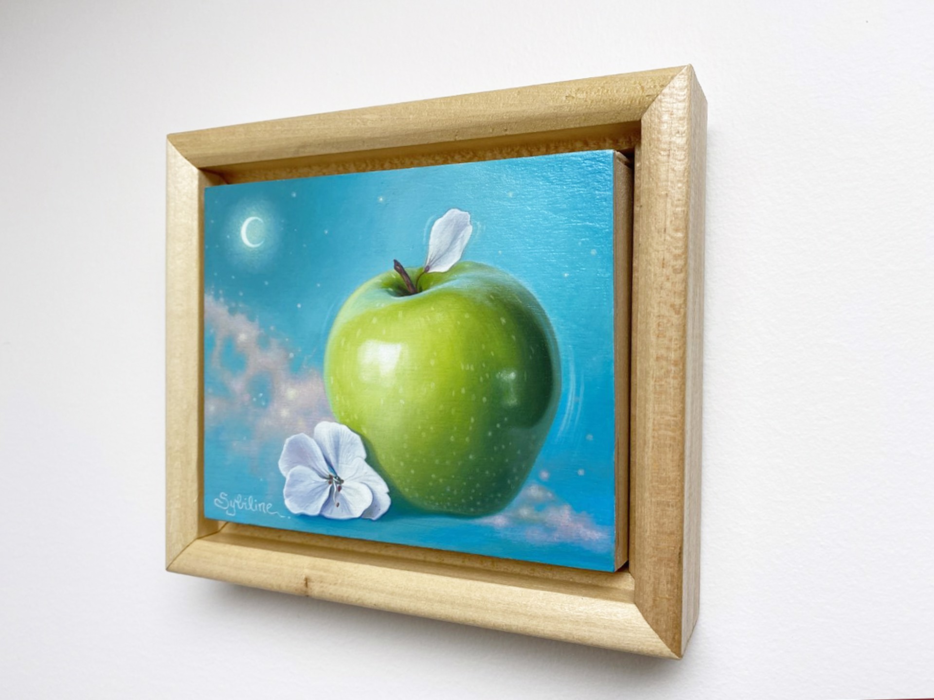A painting of a green apple and a white flower.