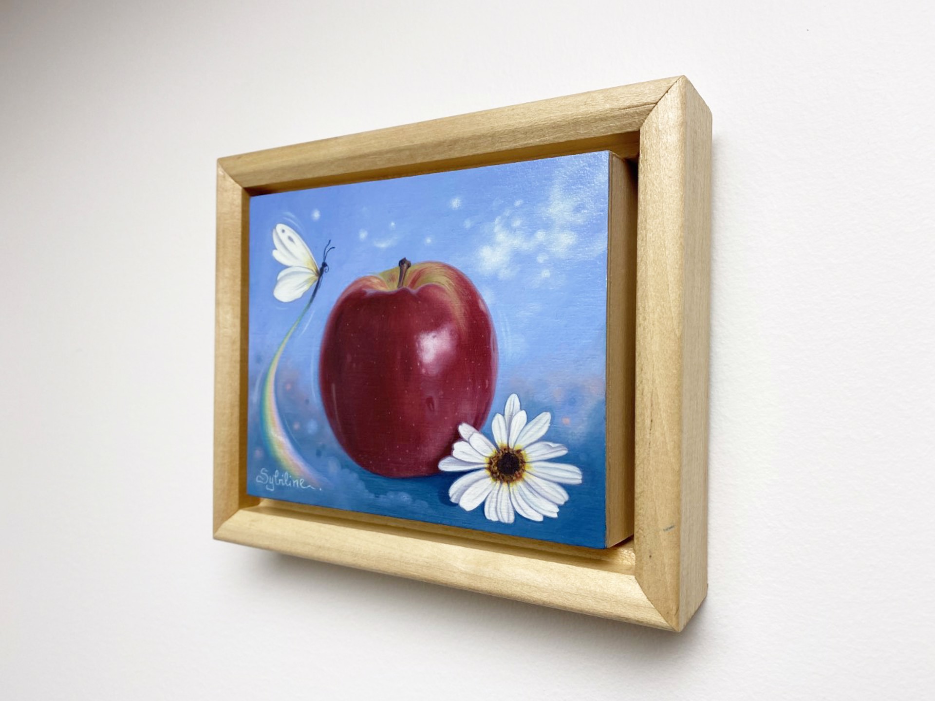A painting of an apple and a butterfly on a blue background.