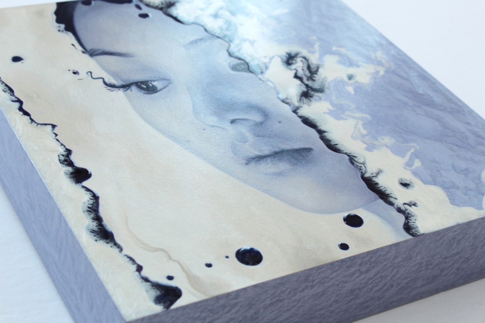 A painting of a woman's face peeking out of a hole in a wall.
