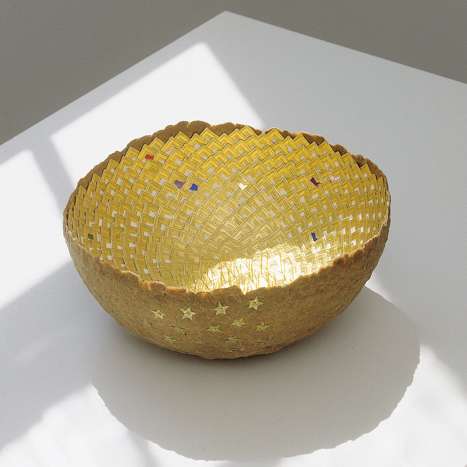 A yellow bowl sitting on top of a white table.