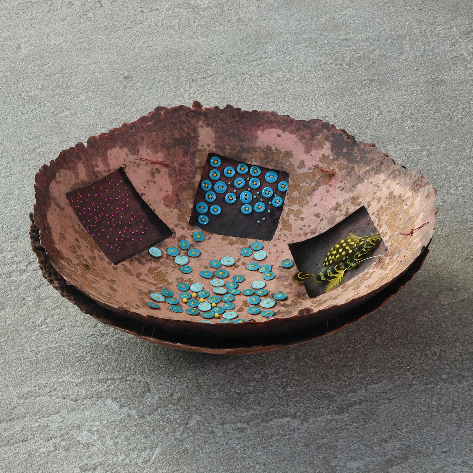 A metal bowl with a bunch of buttons on it.