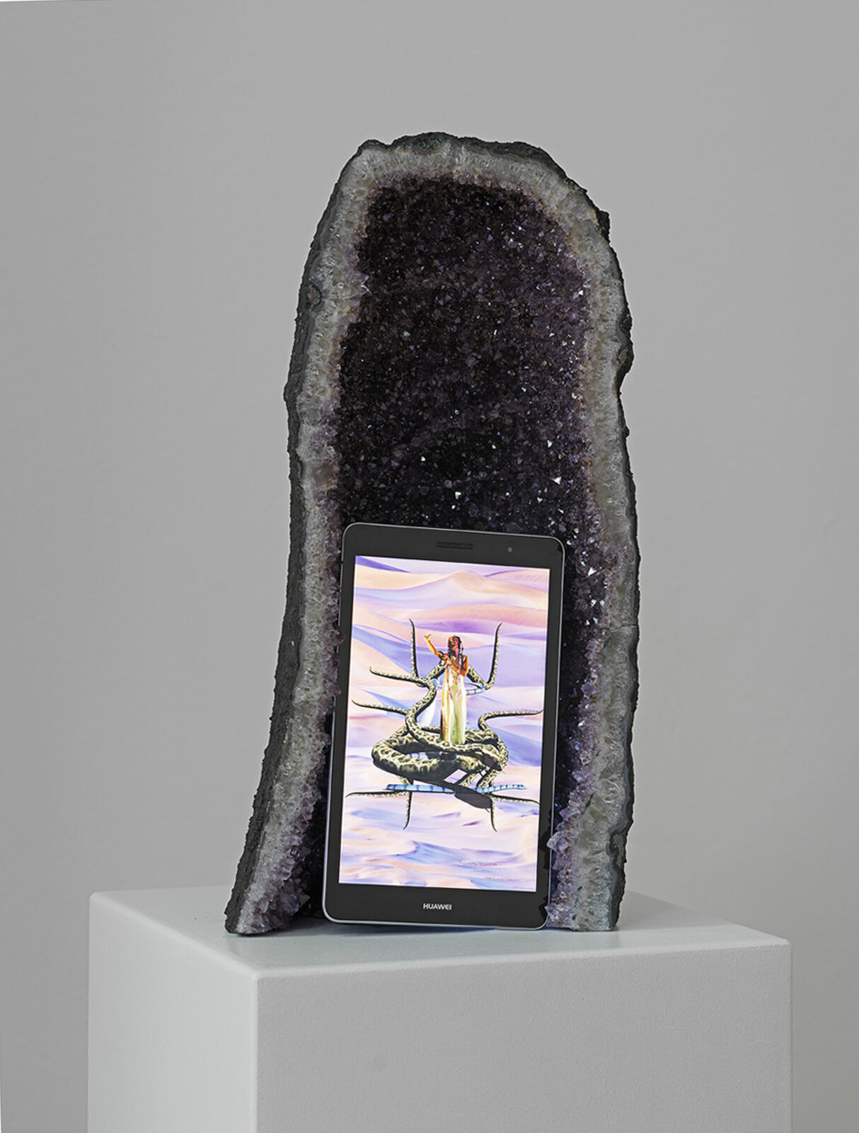 A tablet computer sitting on top of a white pedestal.