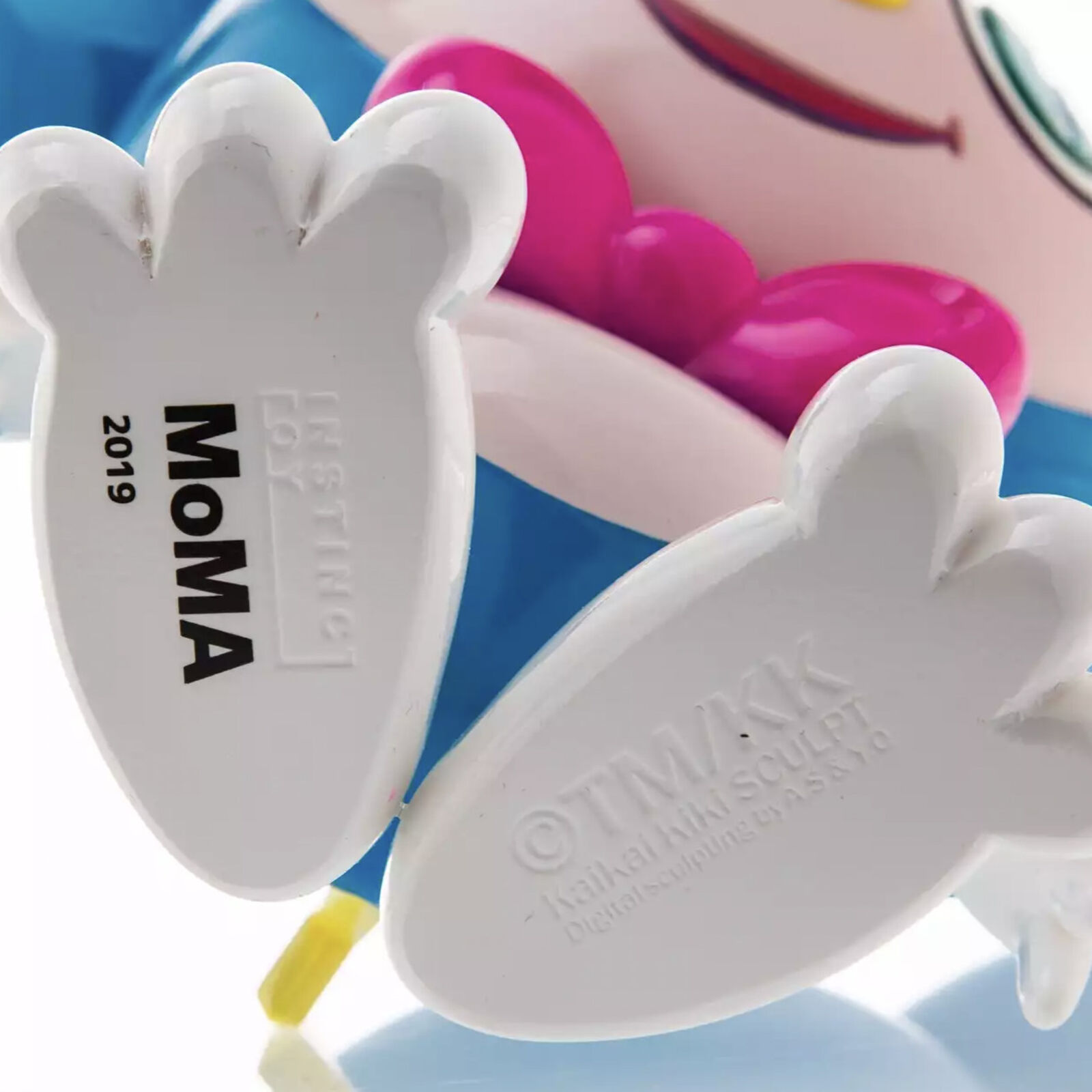 A blue and white toy with a pink bow tie.