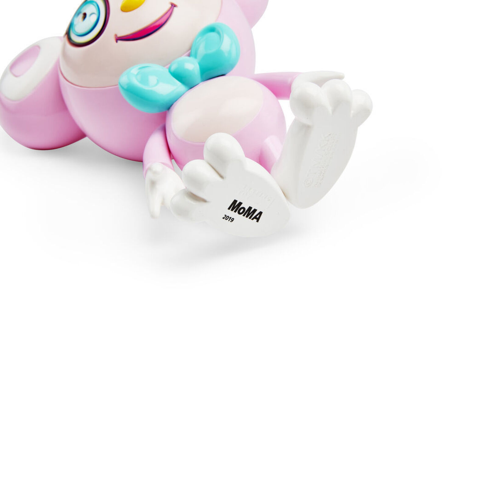 A pink toy with a blue bow tie on it's head.