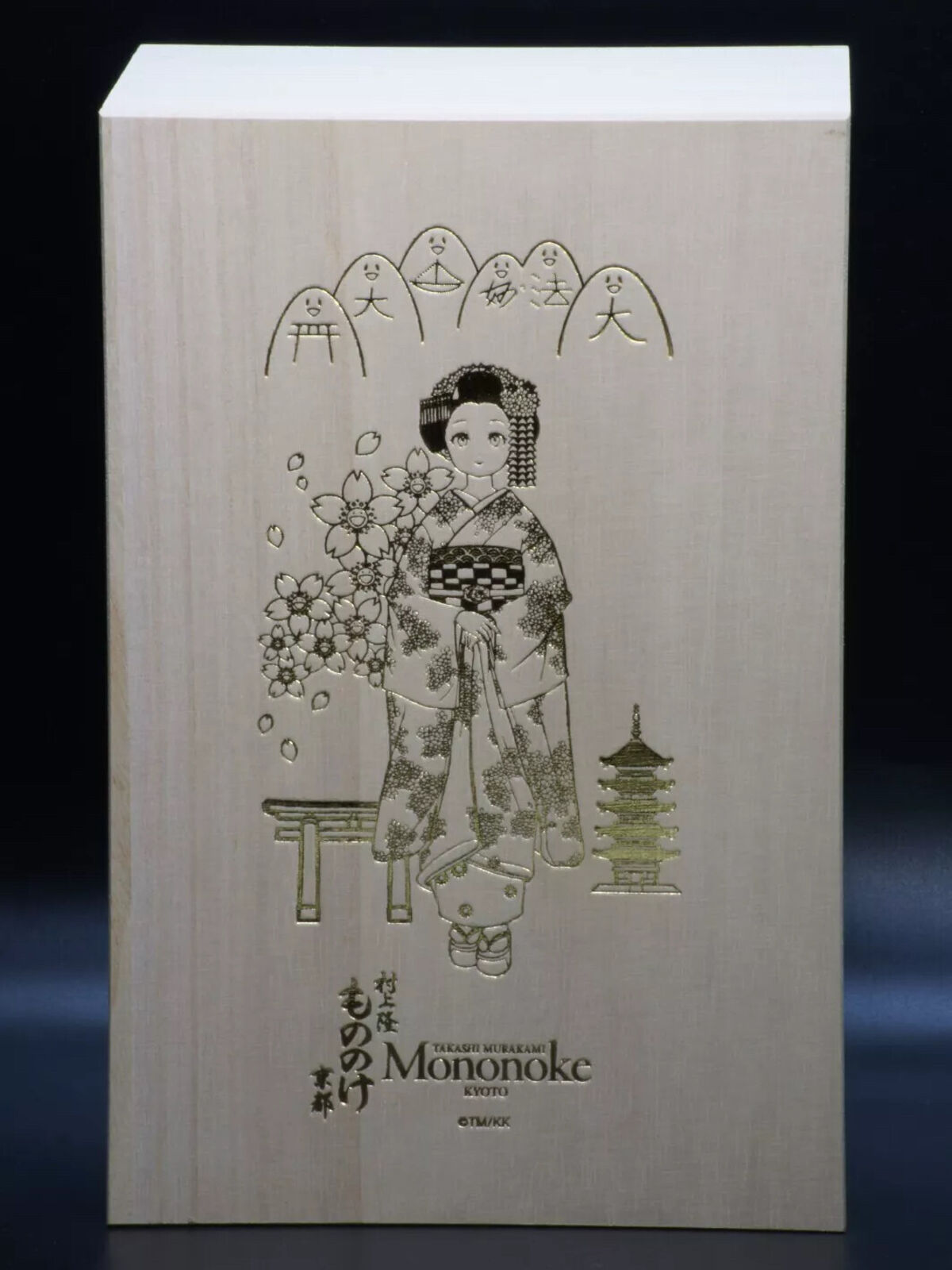 A wooden doll in a wooden box with a picture of a woman in a kimono.