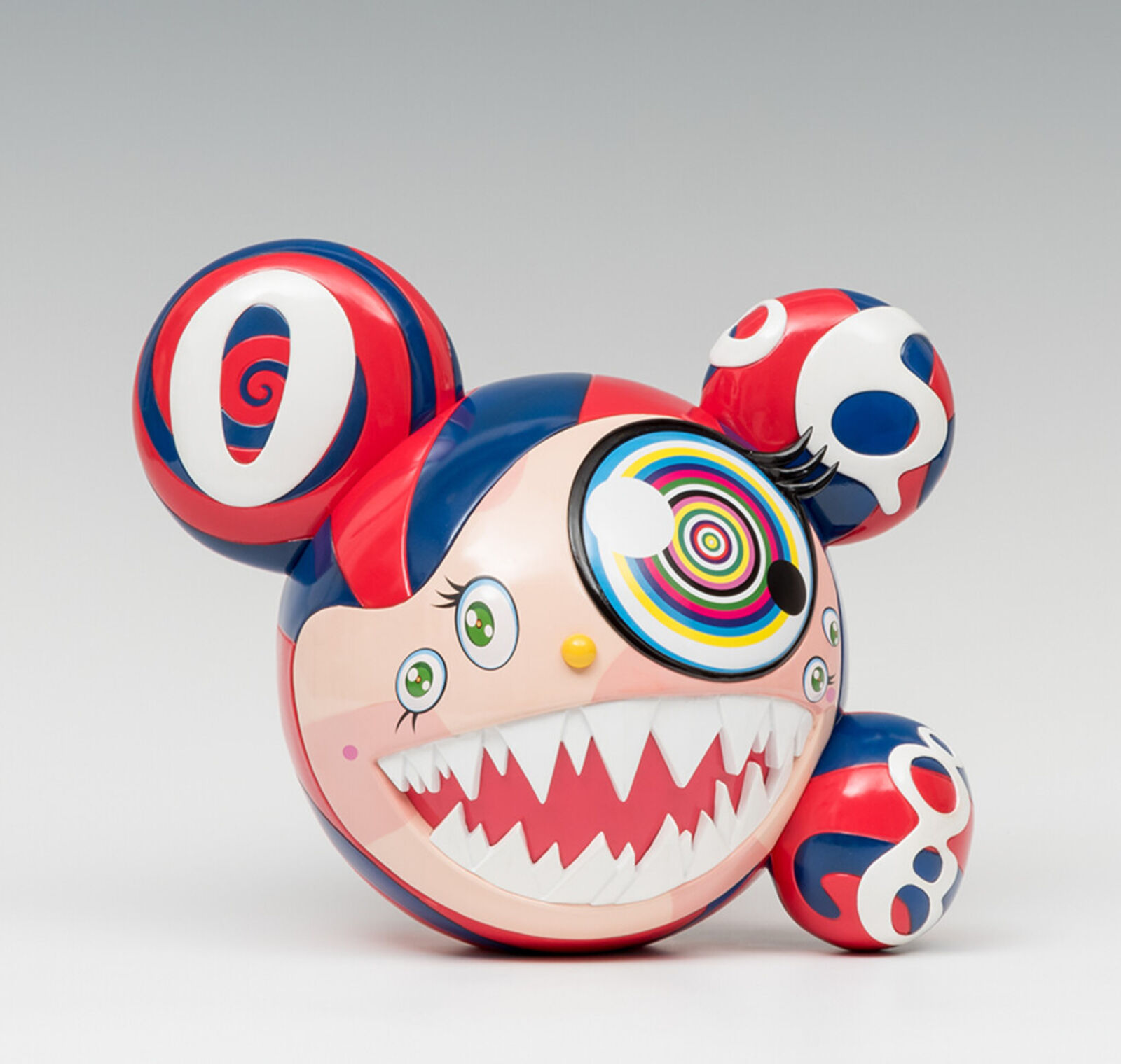 A red, white, and blue toy with a big smile on its face.