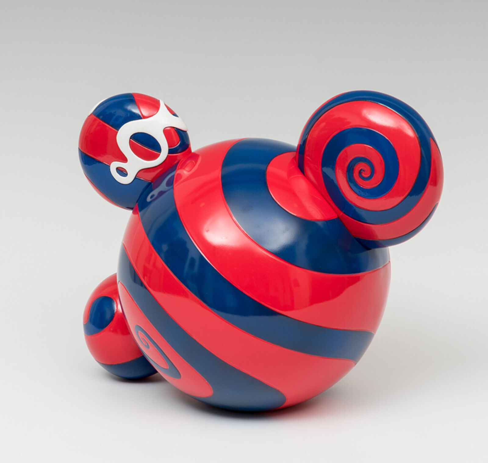 A red, white, and blue toy with a big smile on its face.