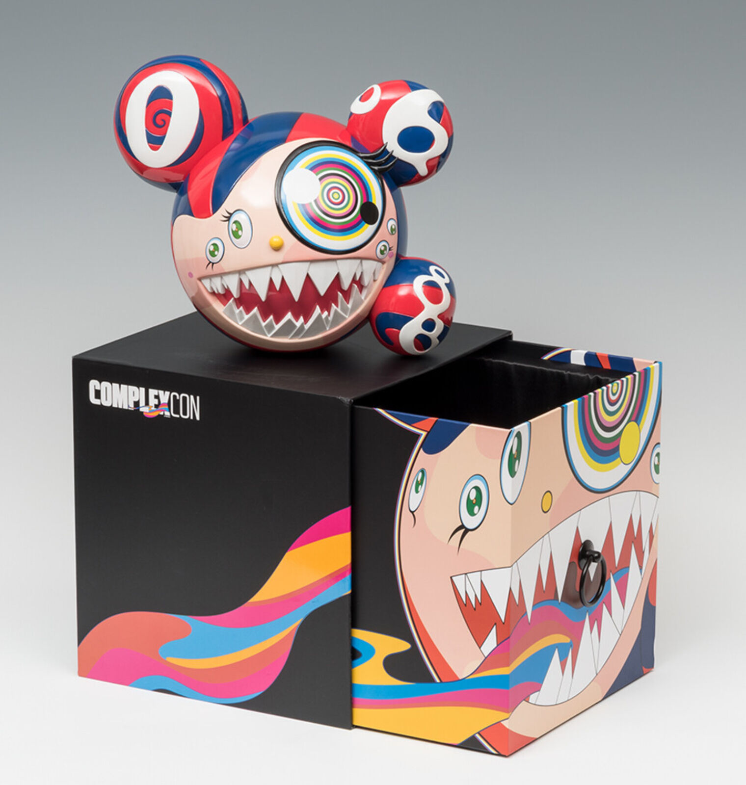 A red, white, and blue toy with a big smile on its face.