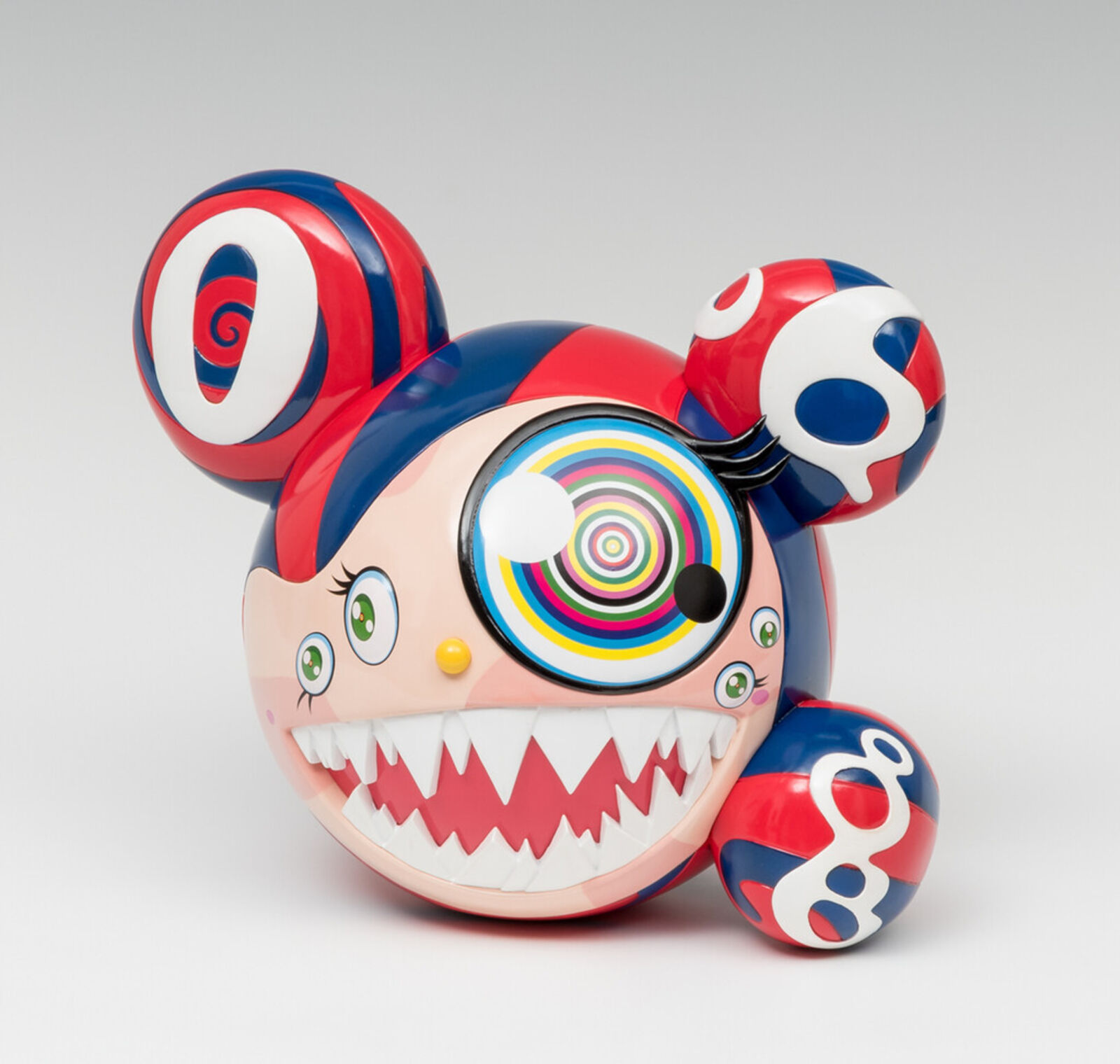 A red, white, and blue toy with a big smile on its face.