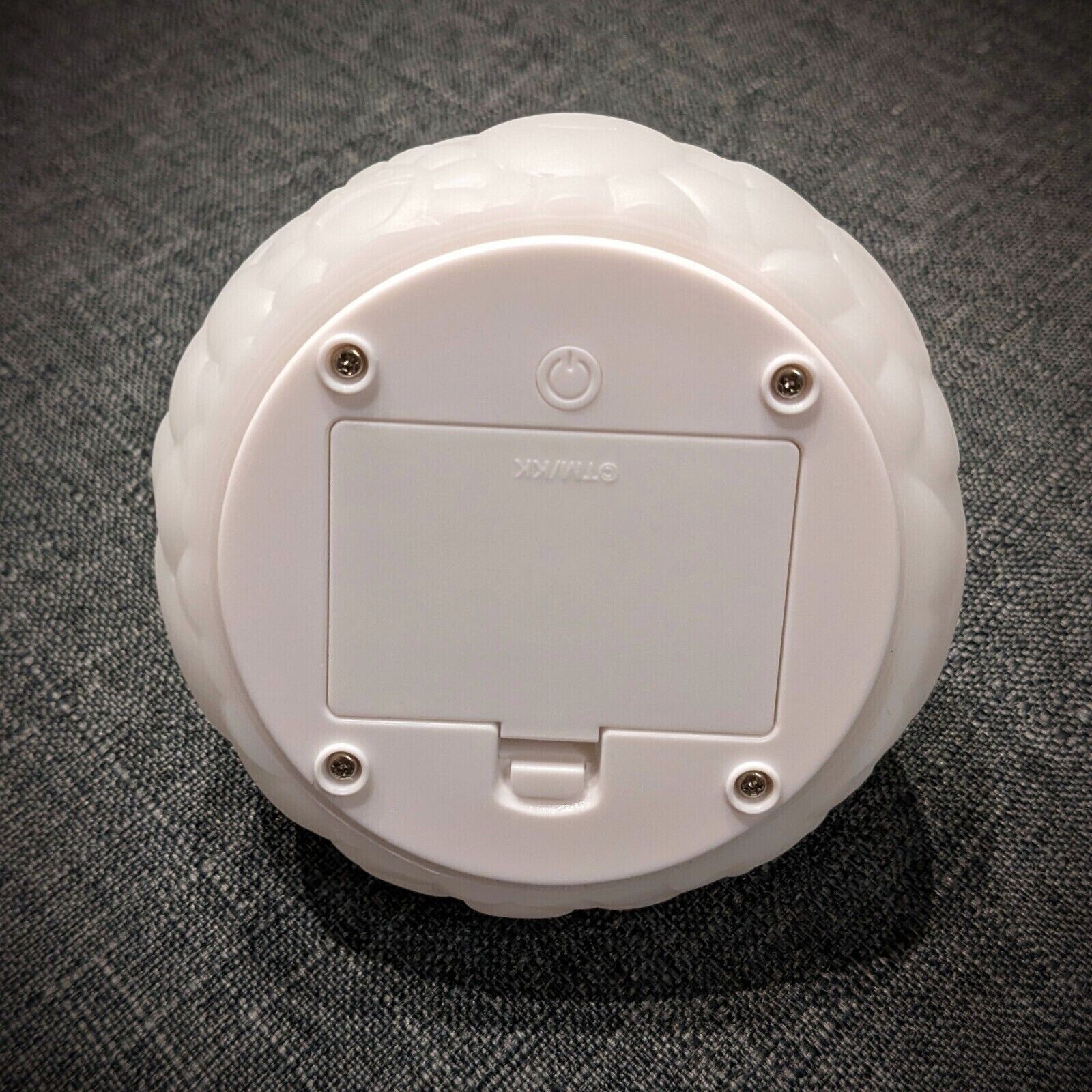 A white turtle shaped lamp on a black background.