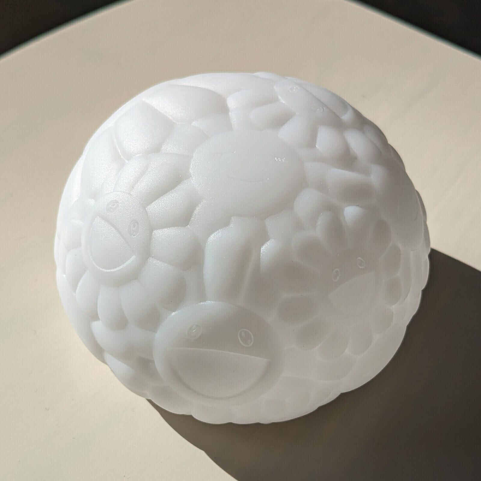A white turtle shaped lamp on a black background.