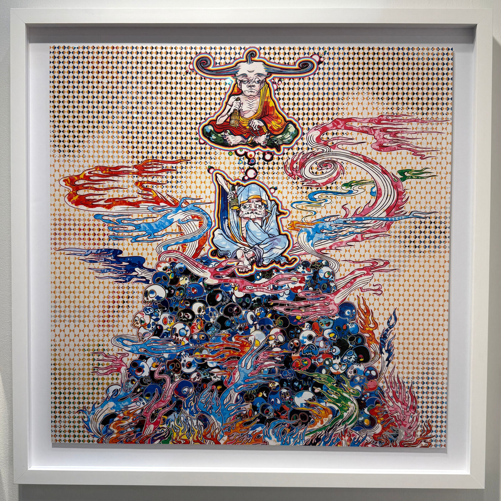 A painting hanging on a wall in a white frame.