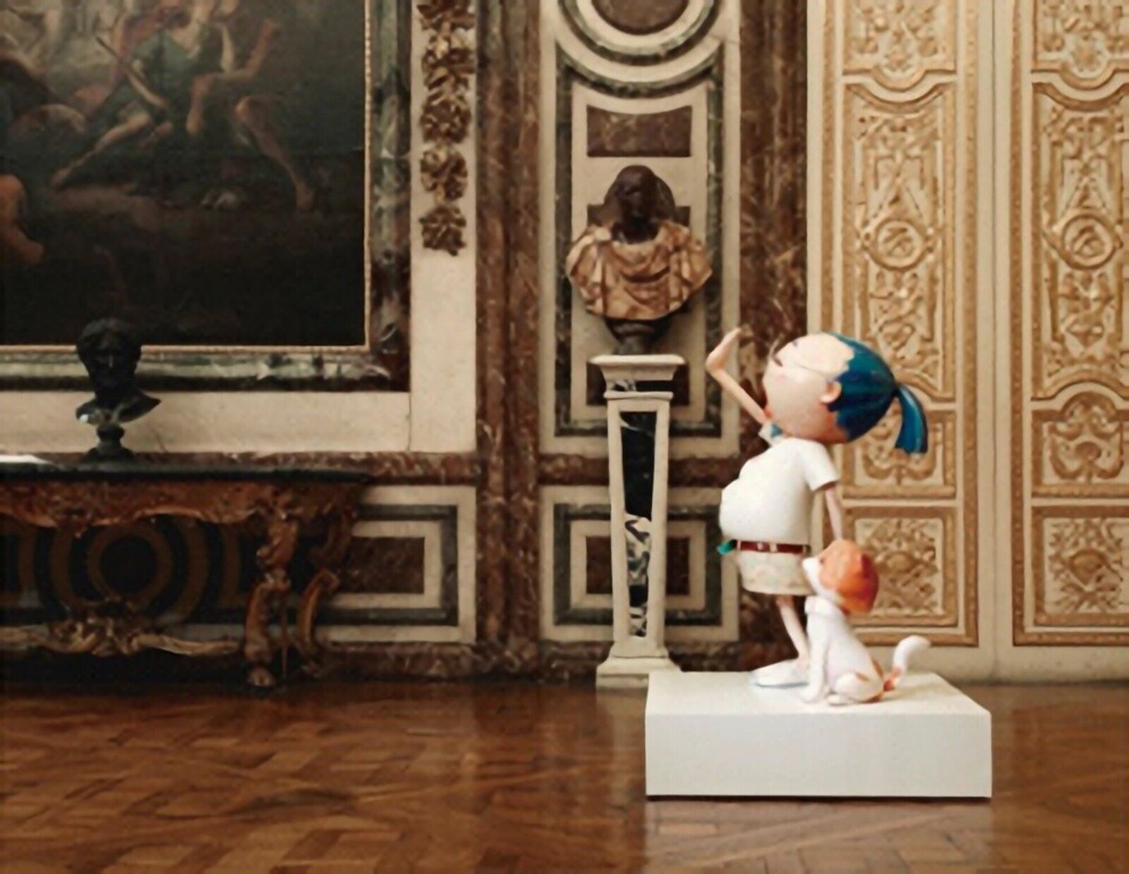 A figurine of a girl and a dog in a room with paintings on the wall.