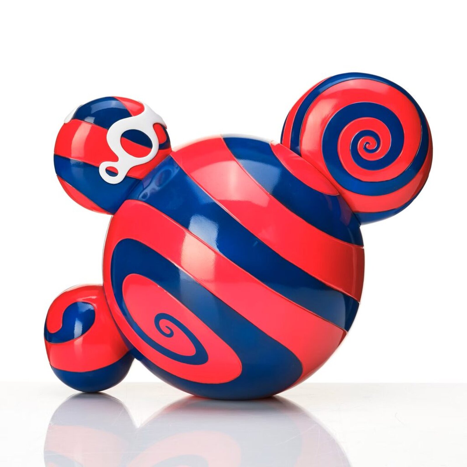 A colorful, cartoonish figure with a large mouth and spiral eye sits beside its matching box.