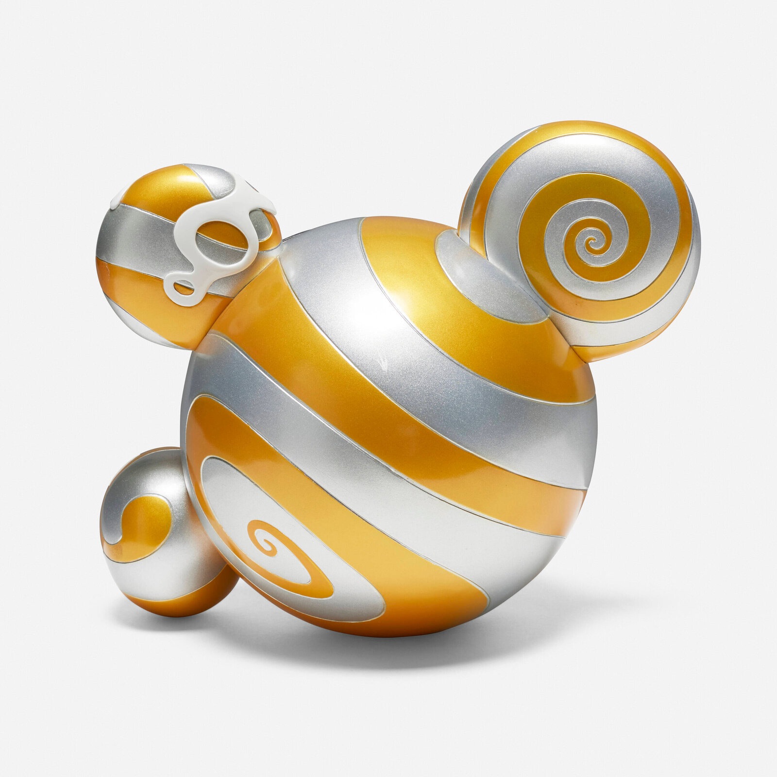A colorful, stylized figure with a wide grin and spiral eyes sits beside its matching box.