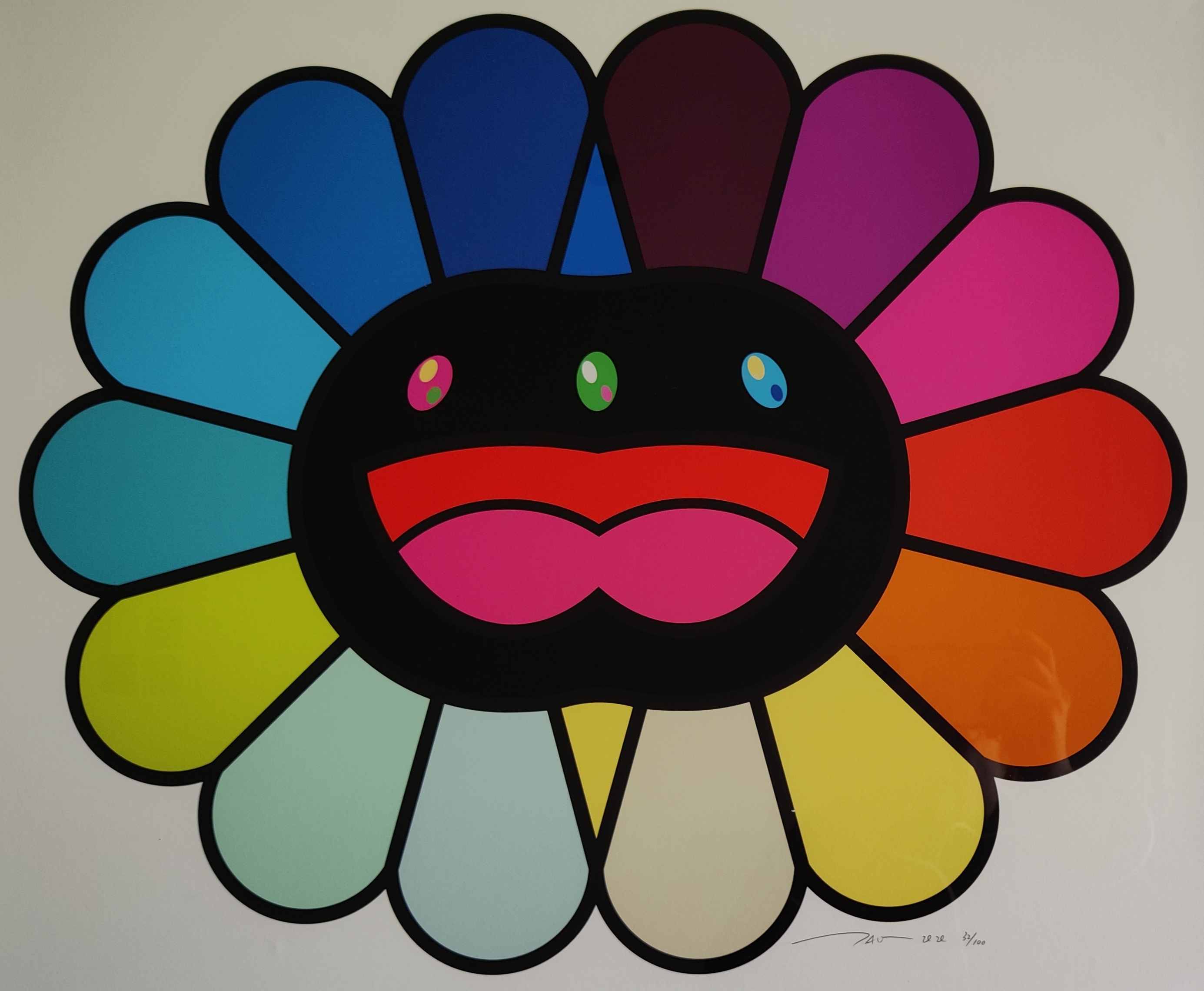 A colorful, stylized flower-like face with a cheerful expression and vibrant petals.