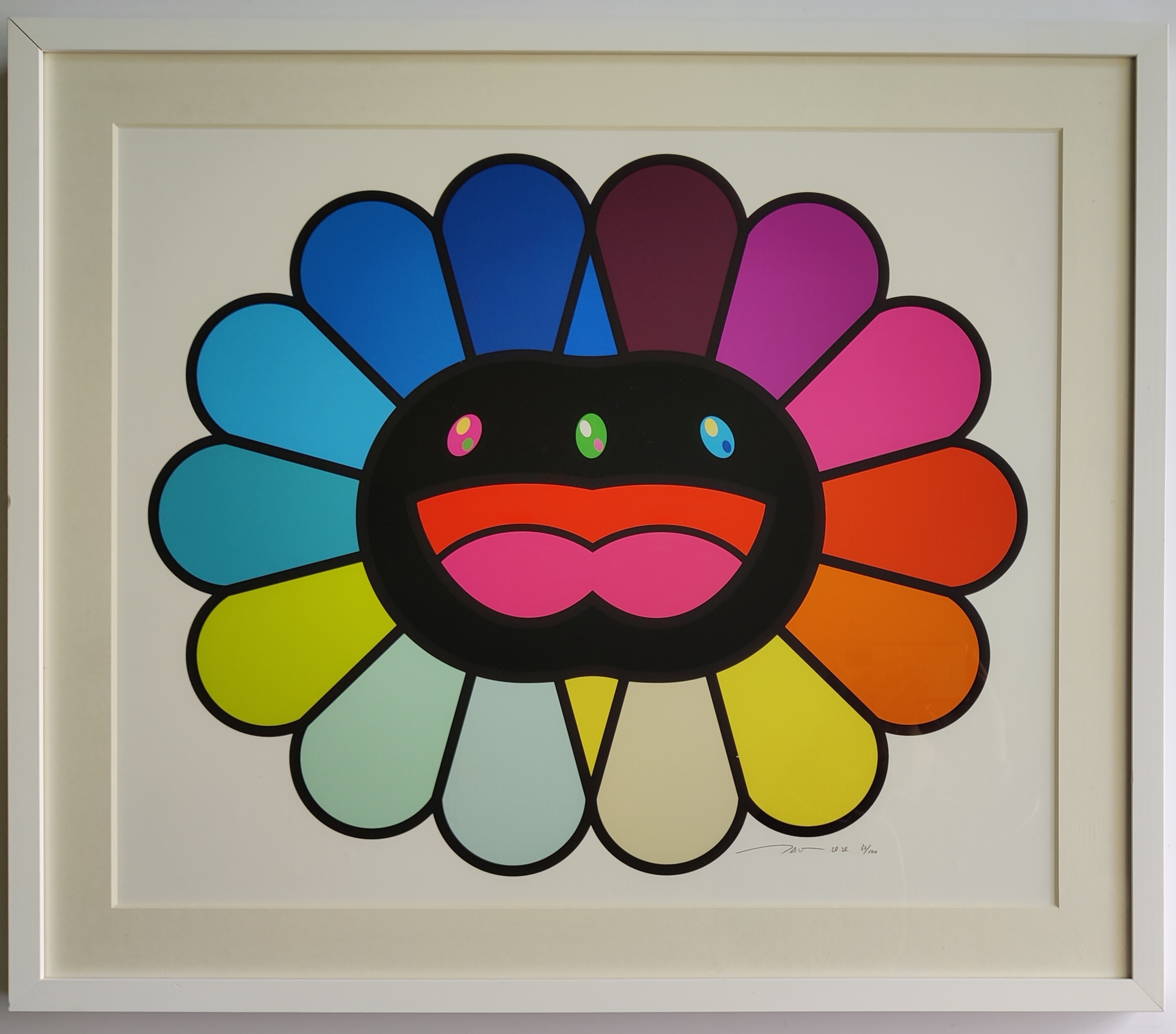 A colorful, stylized flower-like face with a cheerful expression and vibrant petals.