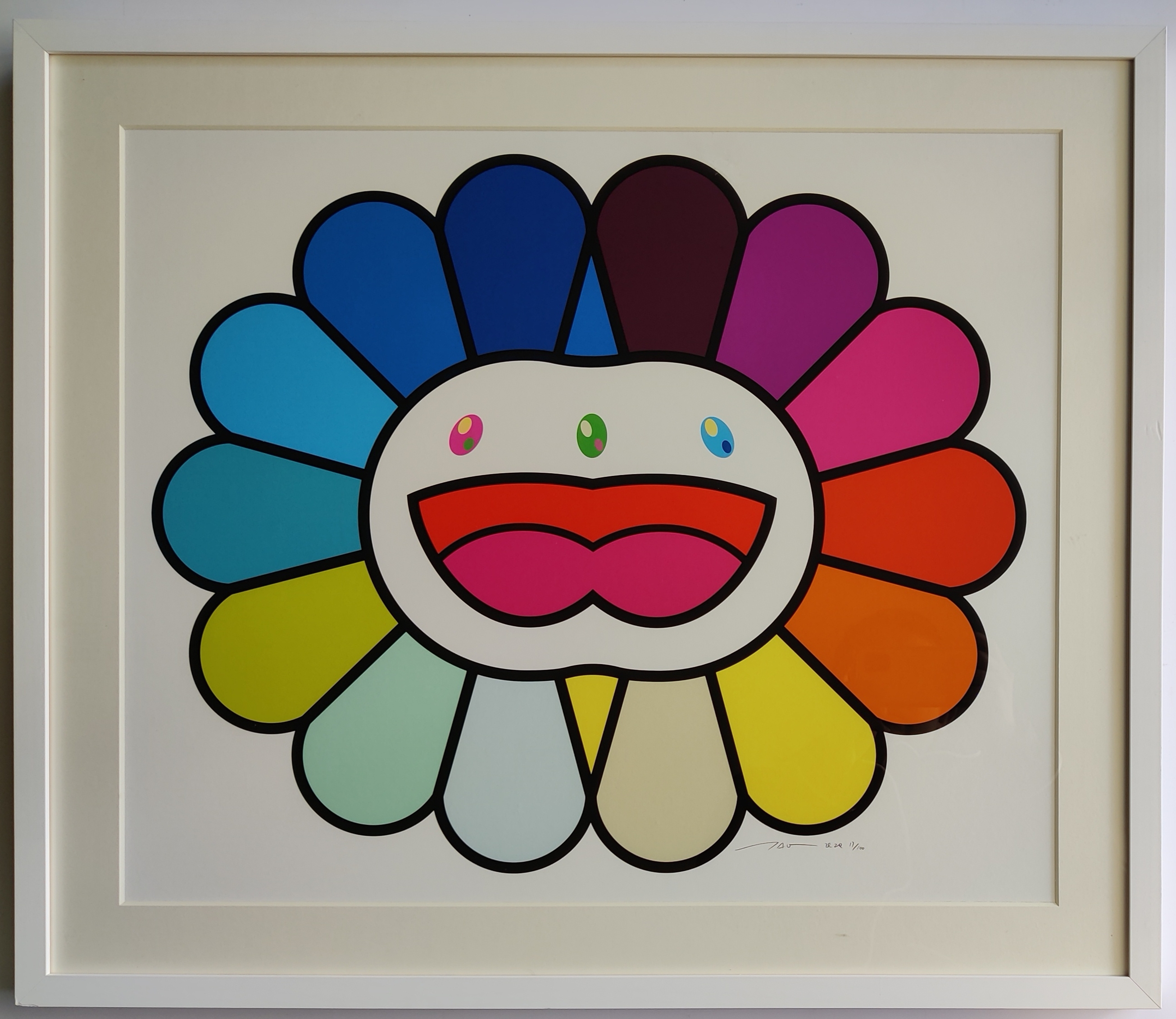 A colorful, stylized flower-like face with a rainbow of petals and a wide, open mouth.