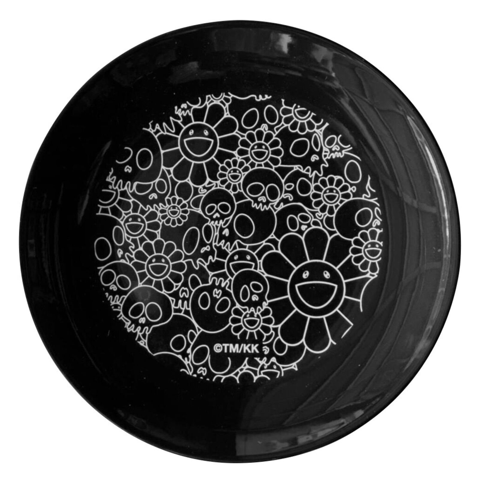 A black plate with a drawing of skulls and flowers on it.