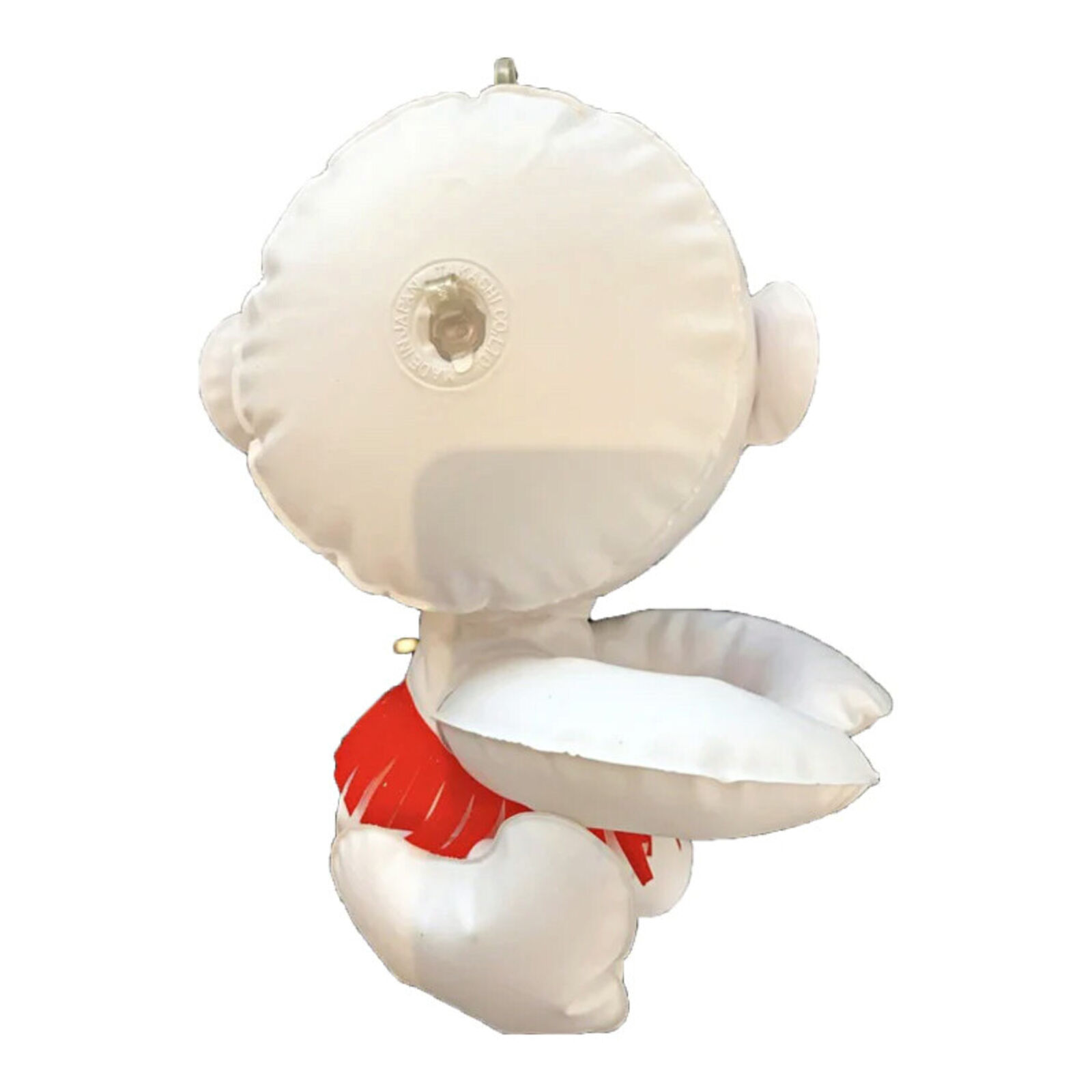 A white robot with a red scarf sitting on a white surface.