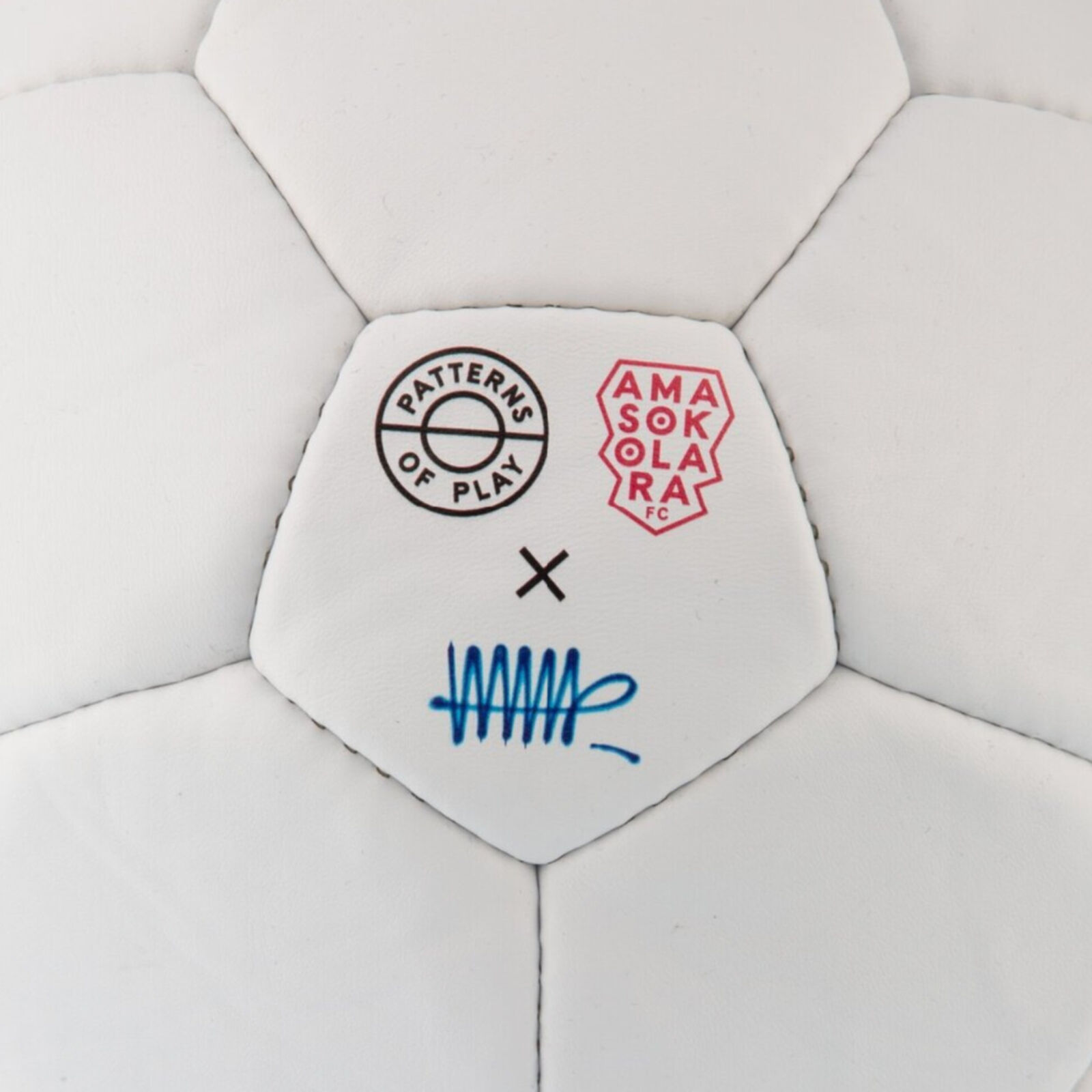 A white soccer ball with blue and red paint splatters on it.